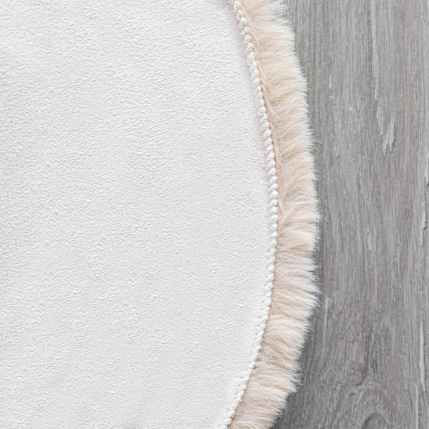 Ein flauschiger, cremefarbener runder Teppich überlappt einen hellen Holzboden und schafft einen Kontrast zwischen weicher Textur und glatter Oberfläche.