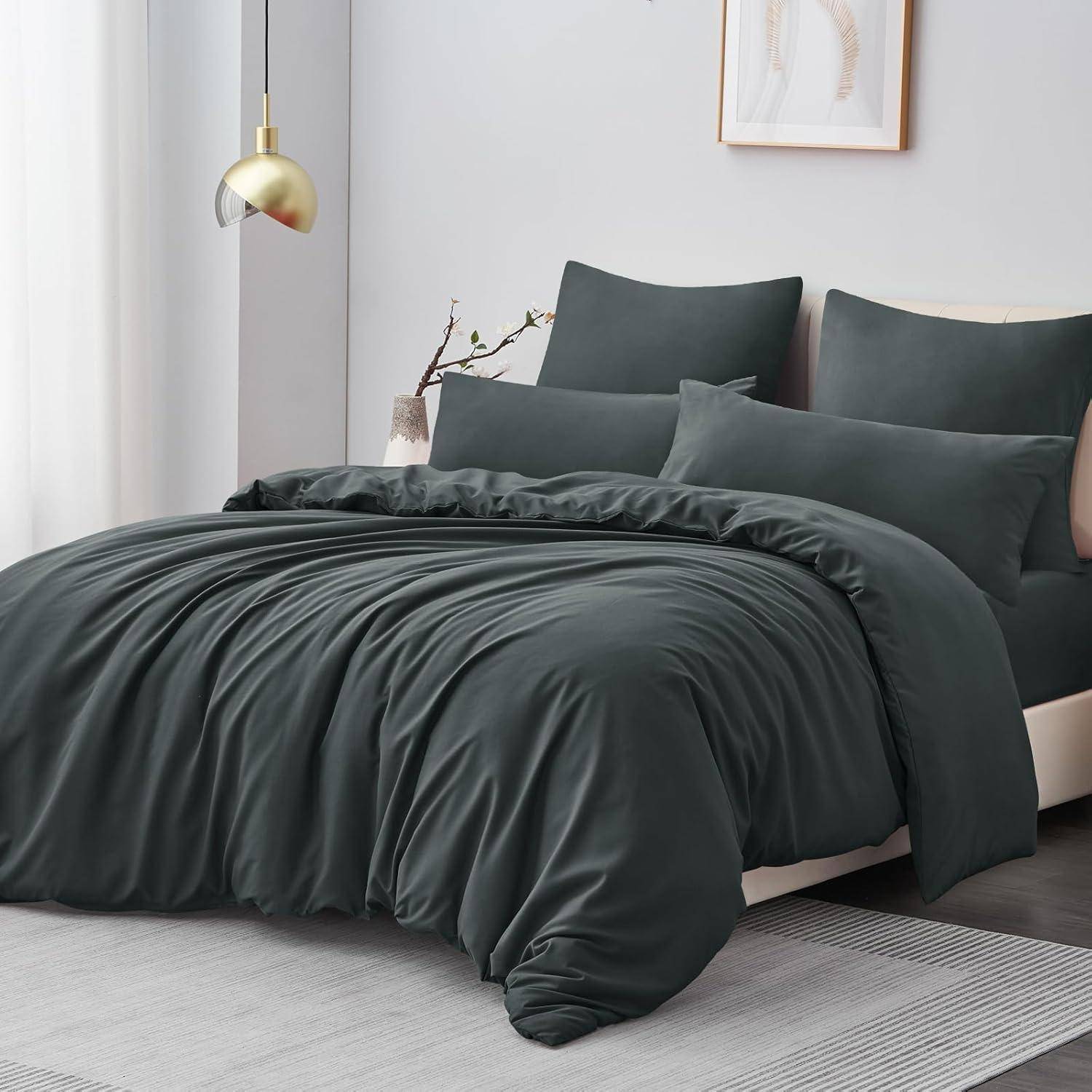 Ein modernes Schlafzimmer präsentiert ein ordentlich gemachtes Bett mit Bettwäsche in Anthrazitgrau, einer hängenden goldenen Lampe und einem schlichten Wandrahmen, wodurch eine gemütliche Atmosphäre entsteht.