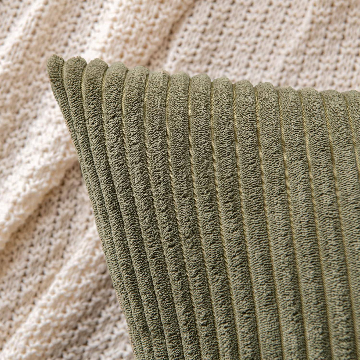 Eine Nahaufnahme eines strukturierten grünen Kissens vor einem cremefarbenen, gestrickten Stoffhintergrund, die die weichen und gemütlichen Materialien betont.