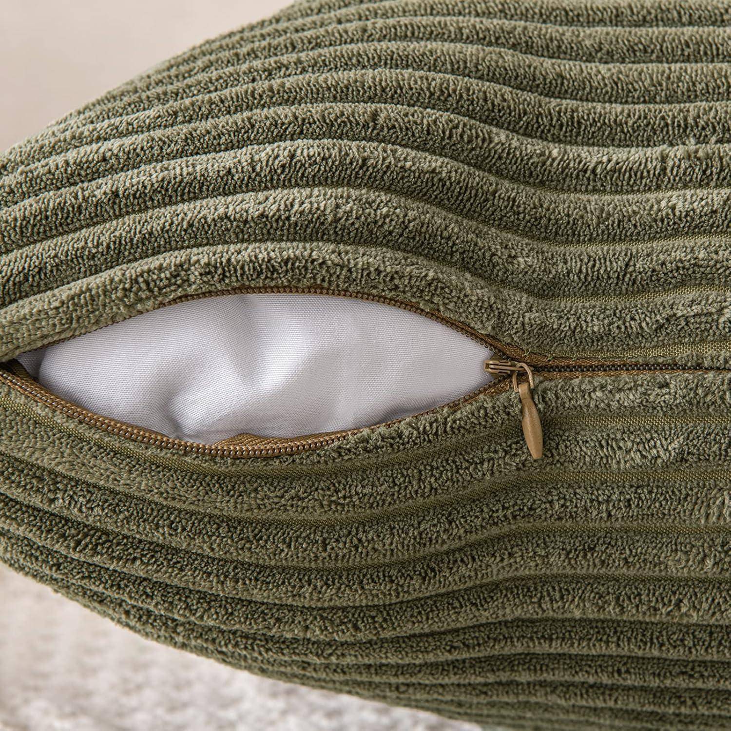 Eine Nahaufnahme eines grünen, strukturierten Kissens mit einem teilweise geöffneten Reißverschluss, der eine weiße Innenfütterung offenbart, auf einer weichen, beigen Oberfläche platziert.
