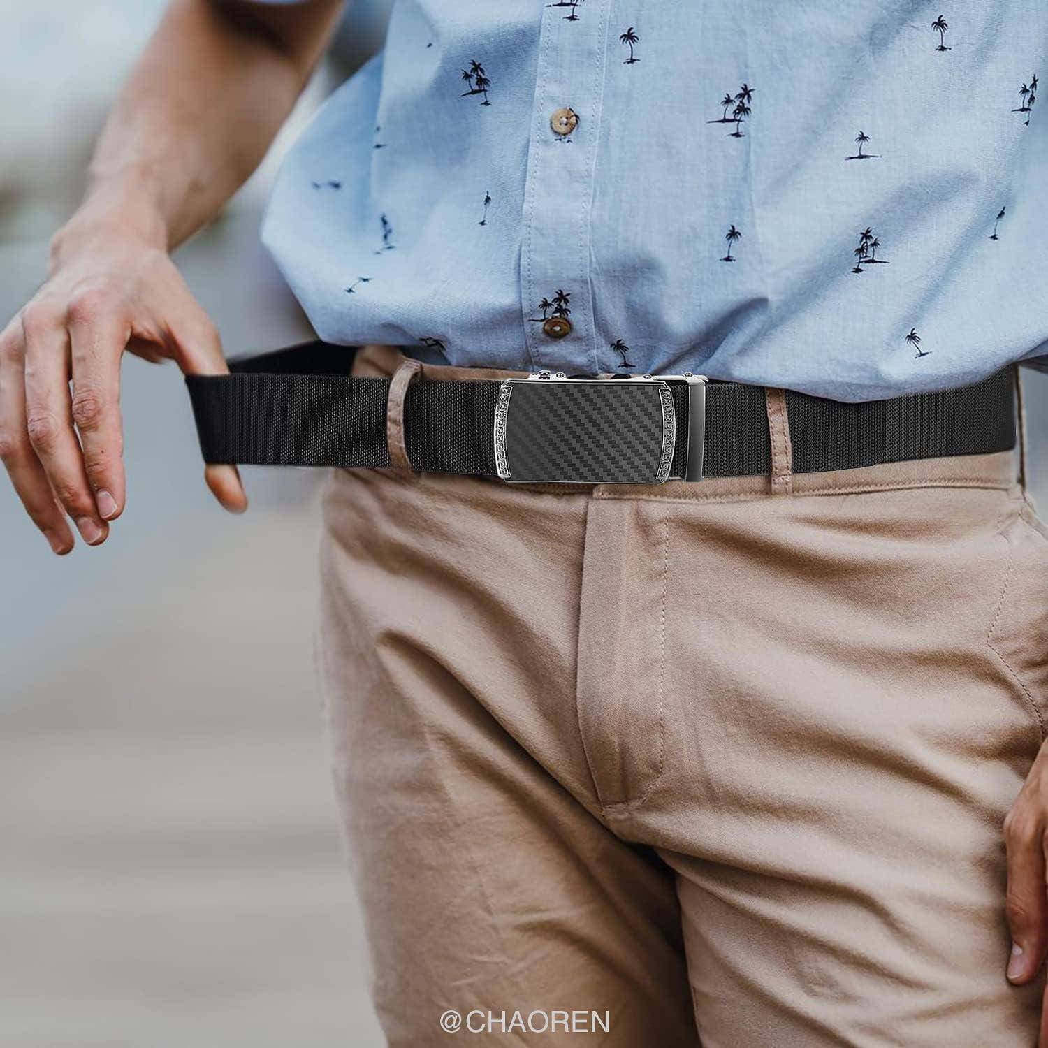 Eine Person trägt ein blaues Hemd mit kleinen Palmenbaum-Mustern, beige Hosen und einen schwarzen Gürtel mit Carbonfaser-Muster und silbernen Details.