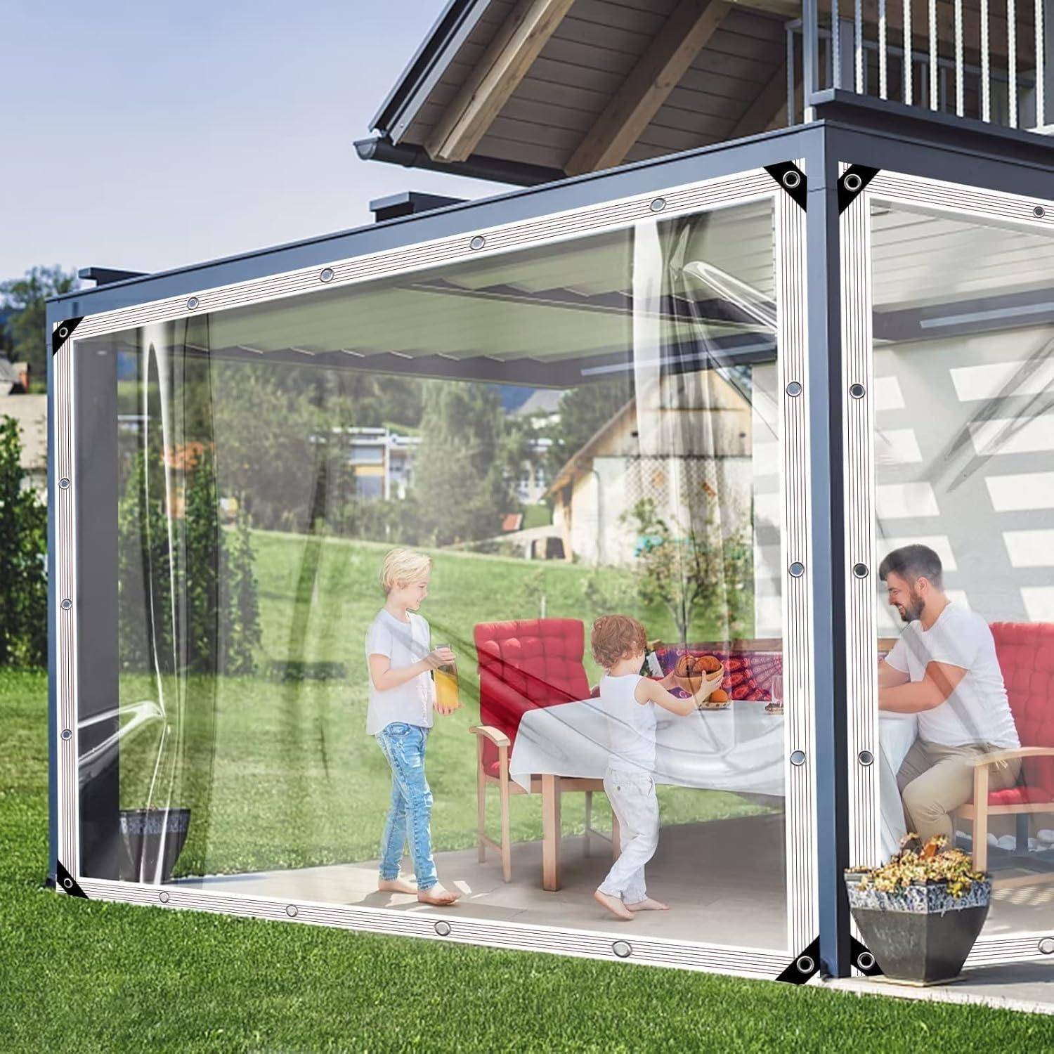 Eine Familie sitzt an einem Tisch in einem transparenten Freisitz, der an ein Haus angebaut ist, mit einem Kind und einem Erwachsenen, die unter einem Vordach miteinander interagieren.