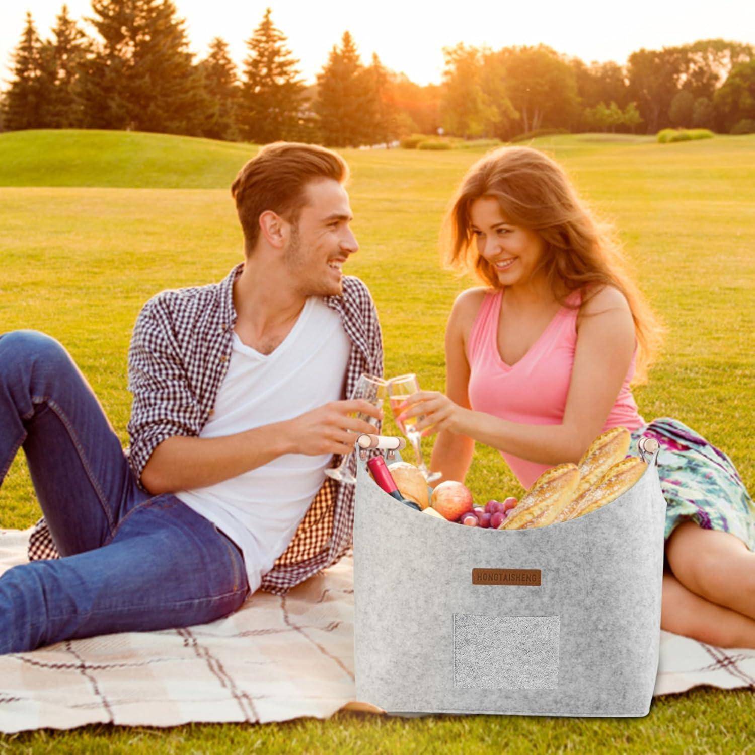 Ein Mann und eine Frau sitzen an einem sonnigen Tag auf dem Gras in einem Park, teilen einen Picknickkorb mit Obst und Brot, lächeln und unterhalten sich.