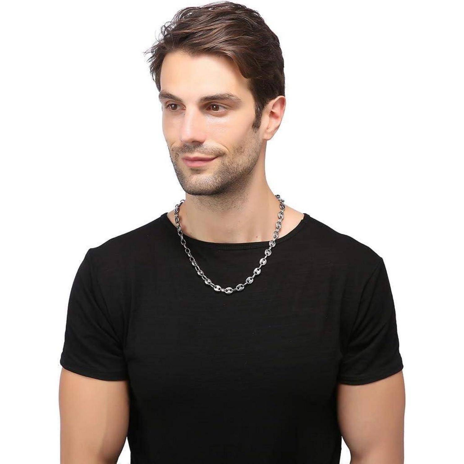 Eine Person mit einem schwarzen T-Shirt und einer silbernen Halskette, die zur Seite blickt.