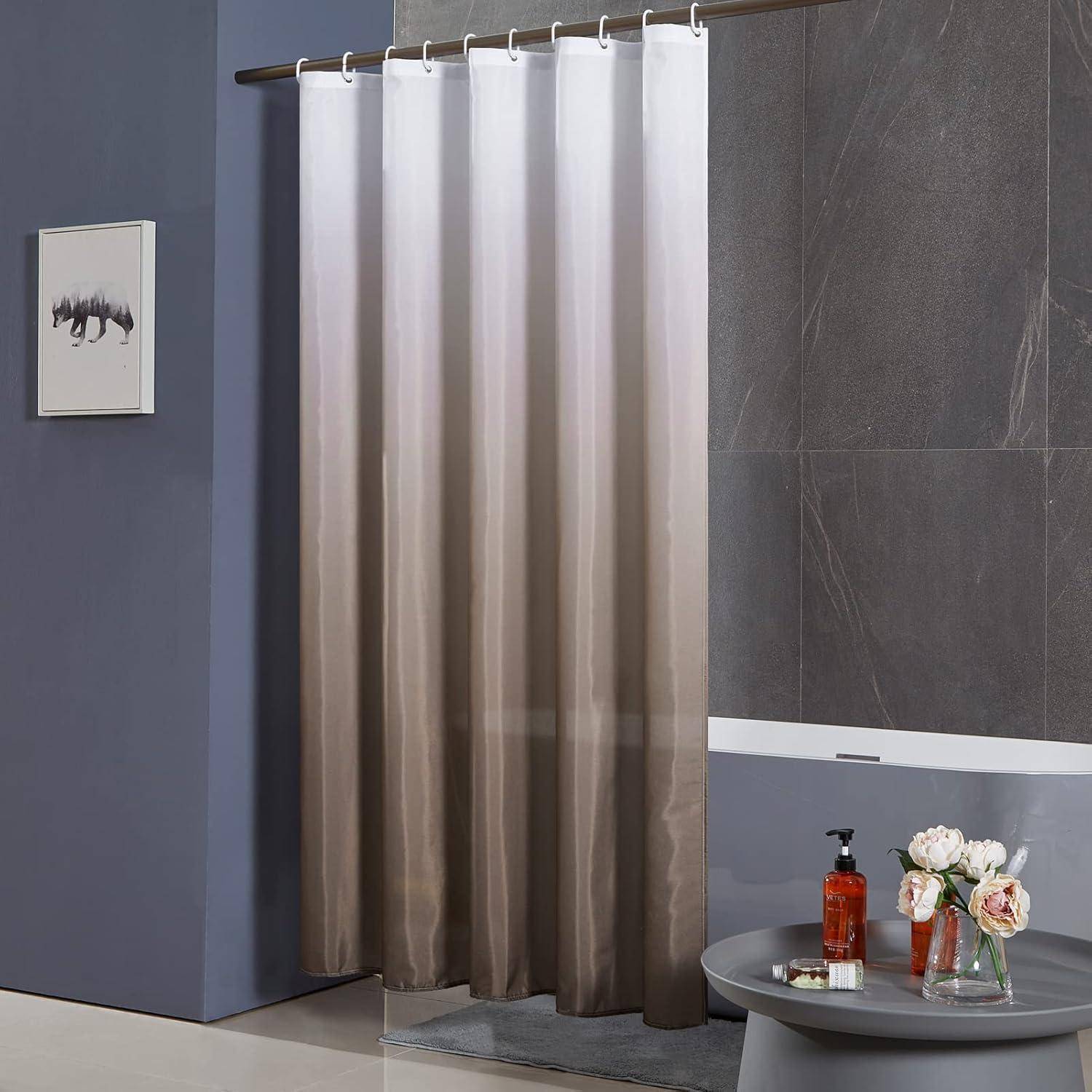 Ein modernes Badezimmer mit einem grauen Ombré-Duschvorhang, beigen gefliesten Wänden und einer Vase mit roten Blumen auf einer dunklen Arbeitsplatte neben einer Badewanne.
