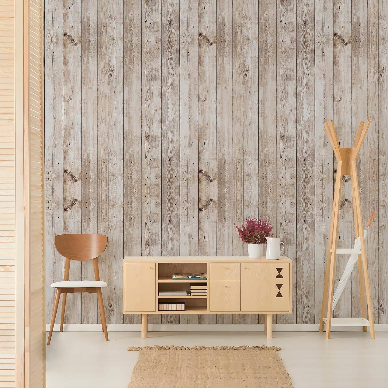 Ein minimalistisches Zimmer mit einem Holzstuhl, einem hellholzfarbenen Sideboard, einer kleinen roten Pflanze und einem hohen Holzgarderobenhaken vor einer Holzvertäfelungswand.