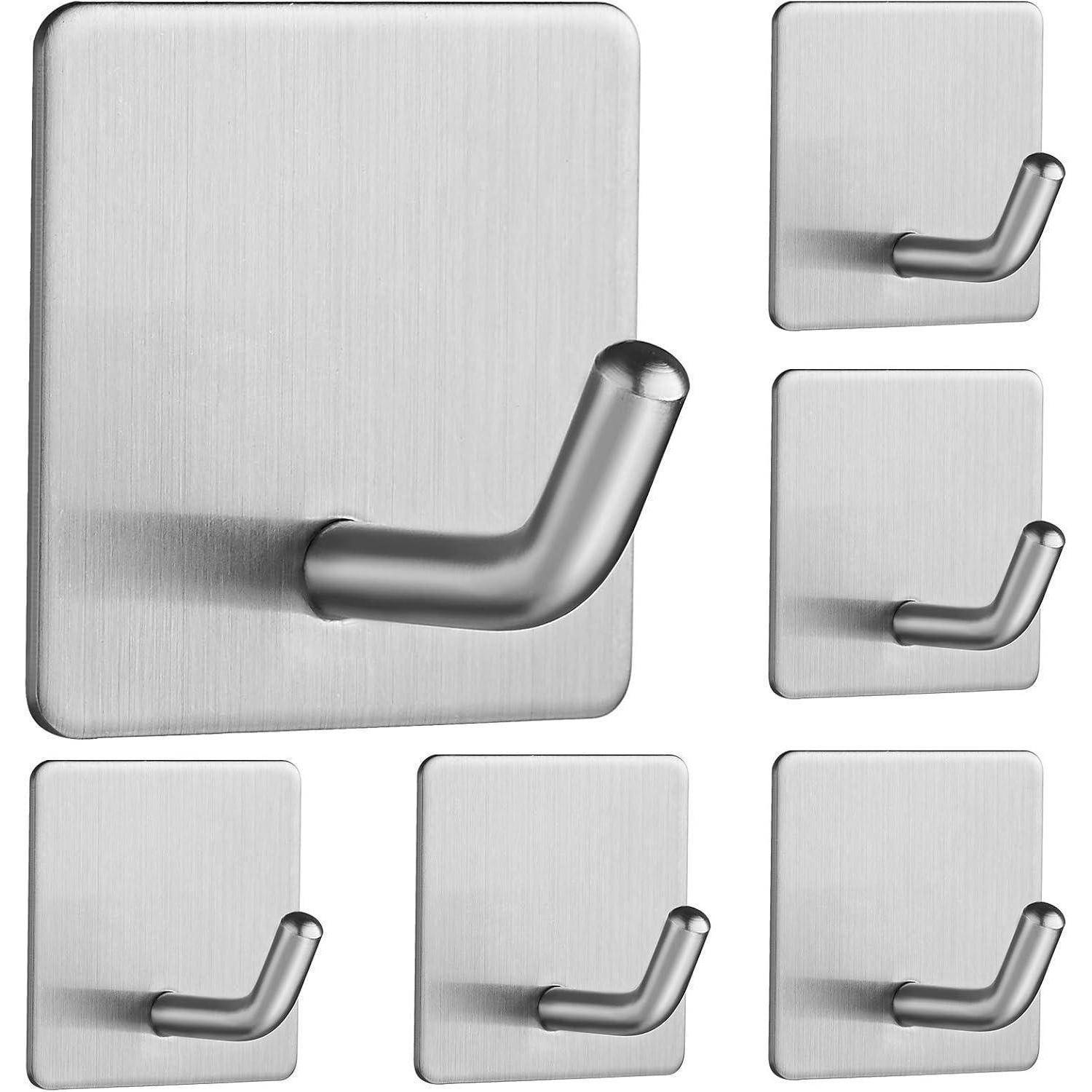 Ein Set aus sechs selbstklebenden Wandhaken aus Edelstahl, die jeweils eine geschwungene Form auf rechteckigen Rückplatten haben. Zum Aufhängen von Gegenständen vorgesehen.