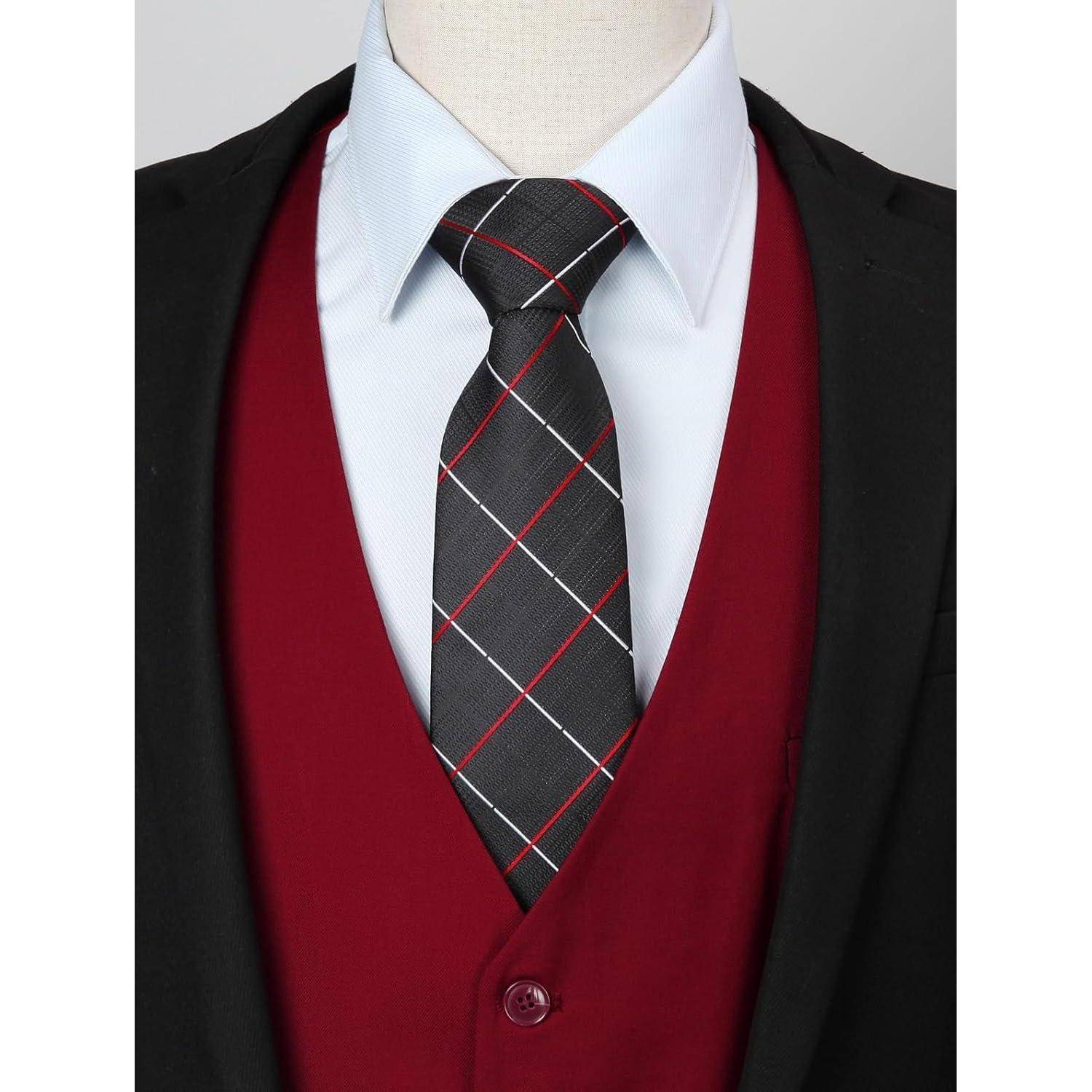 Eine Schaufensterpuppe, gekleidet in ein weißes Hemd mit einer schwarzen Krawatte mit roten und weißen Streifen, einer dunkelroten Weste und einem schwarzen Blazer.