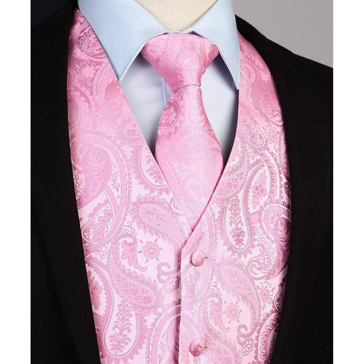 Ein Mann trägt ein hellblaues Hemd mit Kragen, eine leuchtend pinke Krawatte mit Paisley-Muster und eine passende Weste, unter einem schwarzen Sakko.