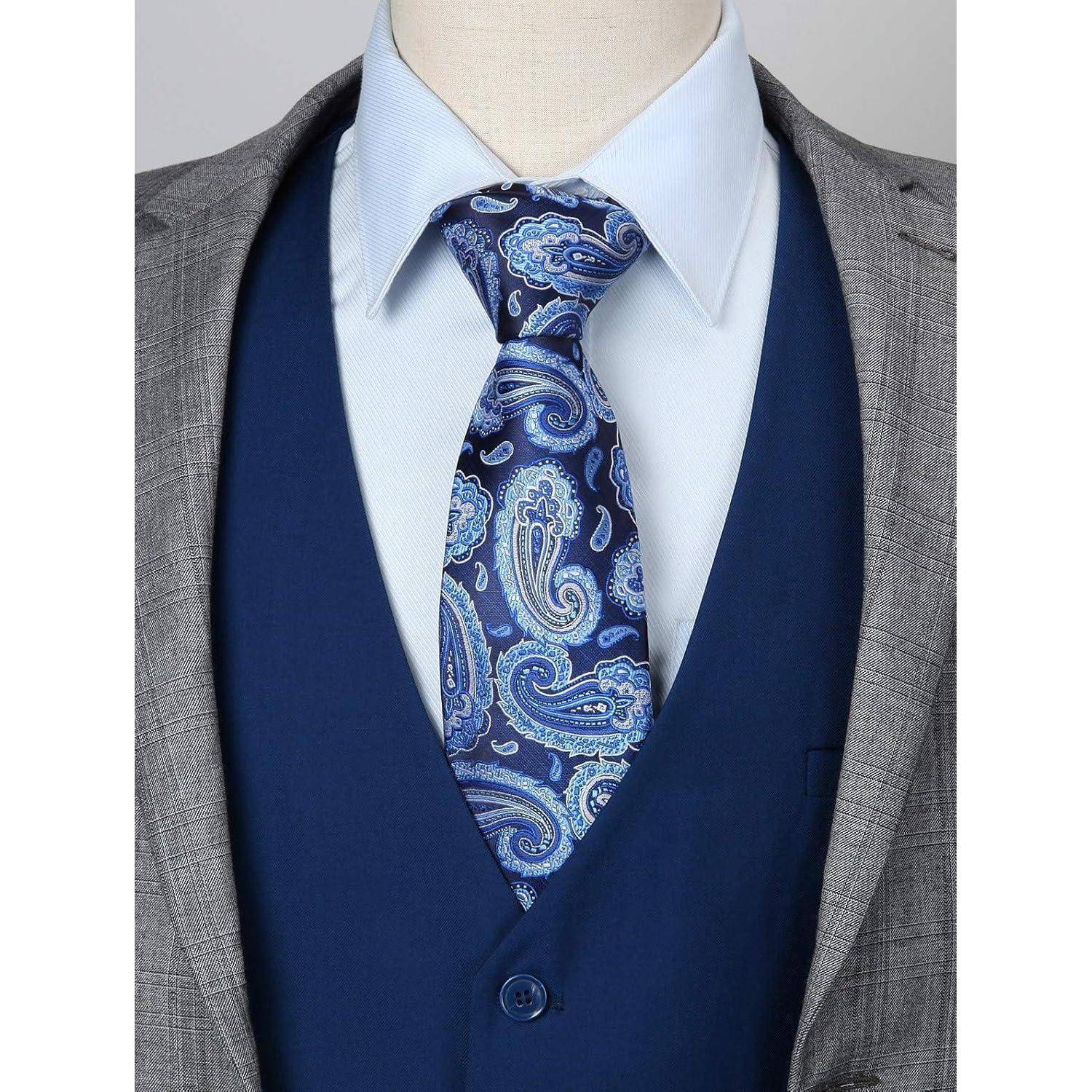 Eine Schaufensterpuppe trägt eine blaue Paisley-Krawatte, ein hellblaues Hemd, eine marineblauer Weste und ein graues Sakko, das einen formellen Anzug präsentiert.