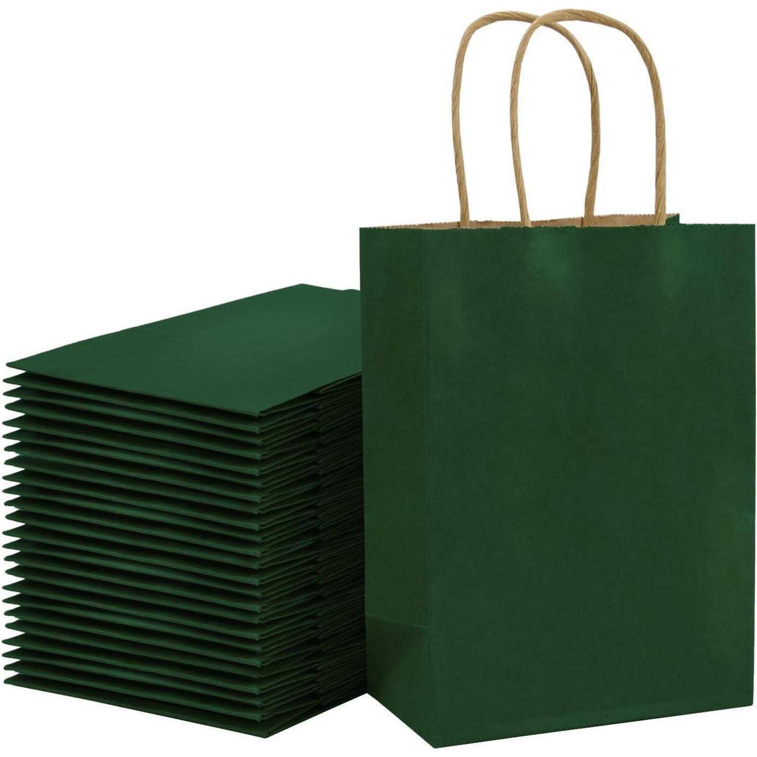 Ein Stapel grüner Papiertüten liegt flach neben einer aufrecht stehenden Tüte, die gedrehte Papierhänkel aufweist und deren Verwendung für Einkäufe oder Geschenke nahelegt.