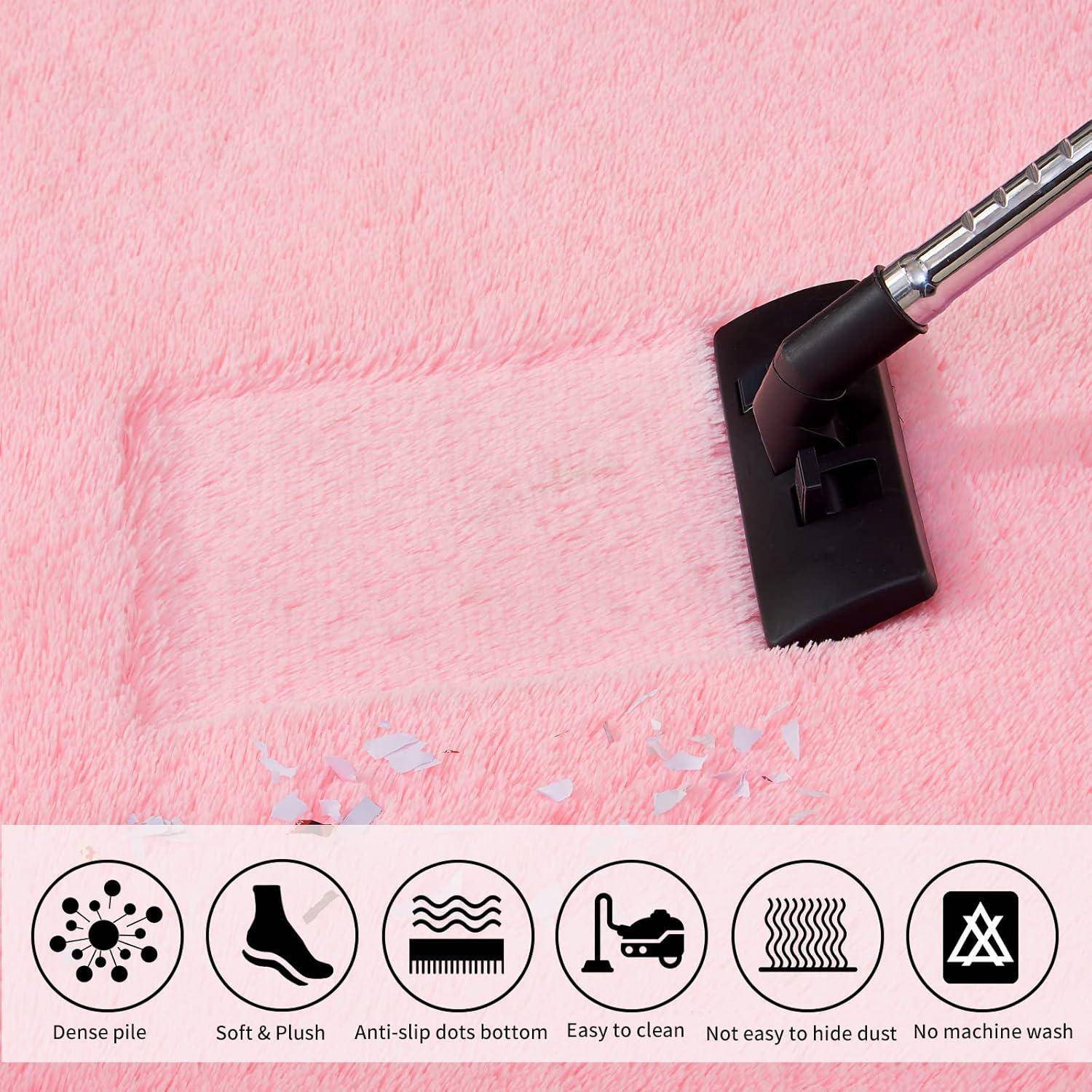 Ein Staubsauger bahnt einen klaren Weg auf einem pinken, flauschigen Teppich und veranschaulicht dadurch effektive Reinigung. Die Symbole darunter heben Produktmerkmale hervor: dichte Polsterung, weicher Plüsch, rutschhemmende Punkte, einfache Reinigung, verbirgt Staub, keine Maschinenwäsche.