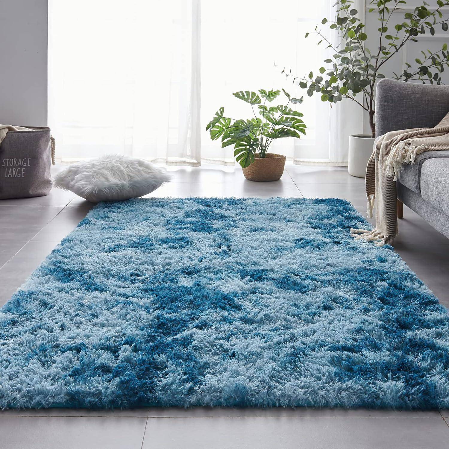 Ein gemütlicher blauer zottiger Teppich auf einem grauen gefliesten Boden in einem Wohnzimmer, mit einem Sofa, Kissen, Pflanzen und einem Flechtkorb für eine beschauliche Atmosphäre.