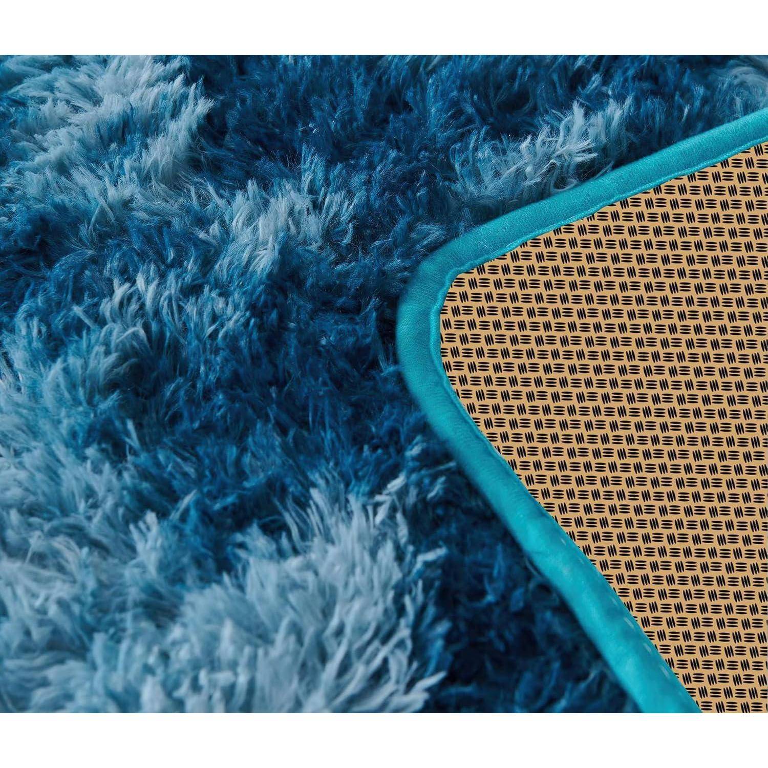 Eine Nahaufnahme eines blauen zottligen Teppichs, der eine gewebte beige Matte überlappt und den Kontrast zwischen weichen und strukturierten Materialien hervorhebt.