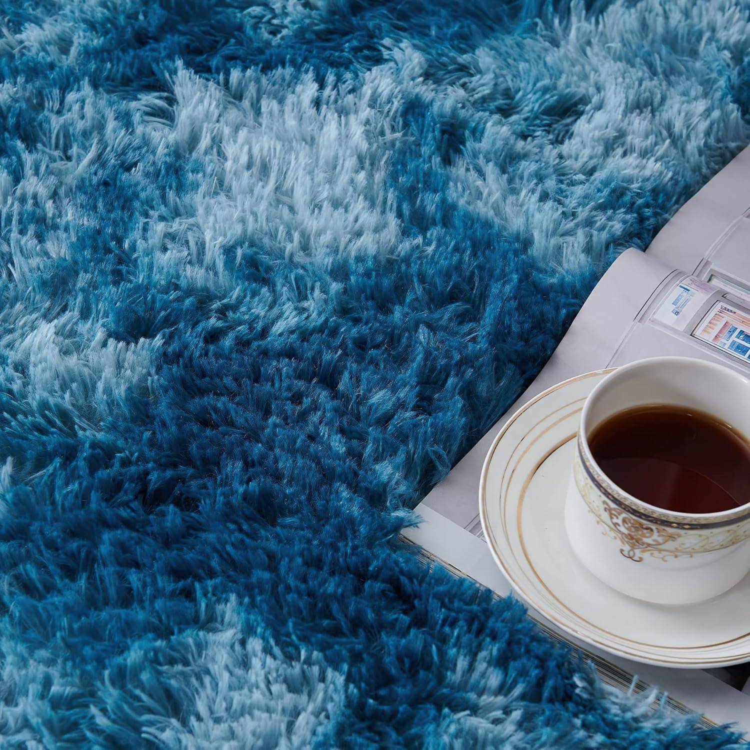Eine dampfende Tasse Tee ruht auf einem weißen Unterteller, der auf einem hellgefärbten Dokument platziert ist und teilweise von einem blauen, flauschigen Teppich bedeckt wird.