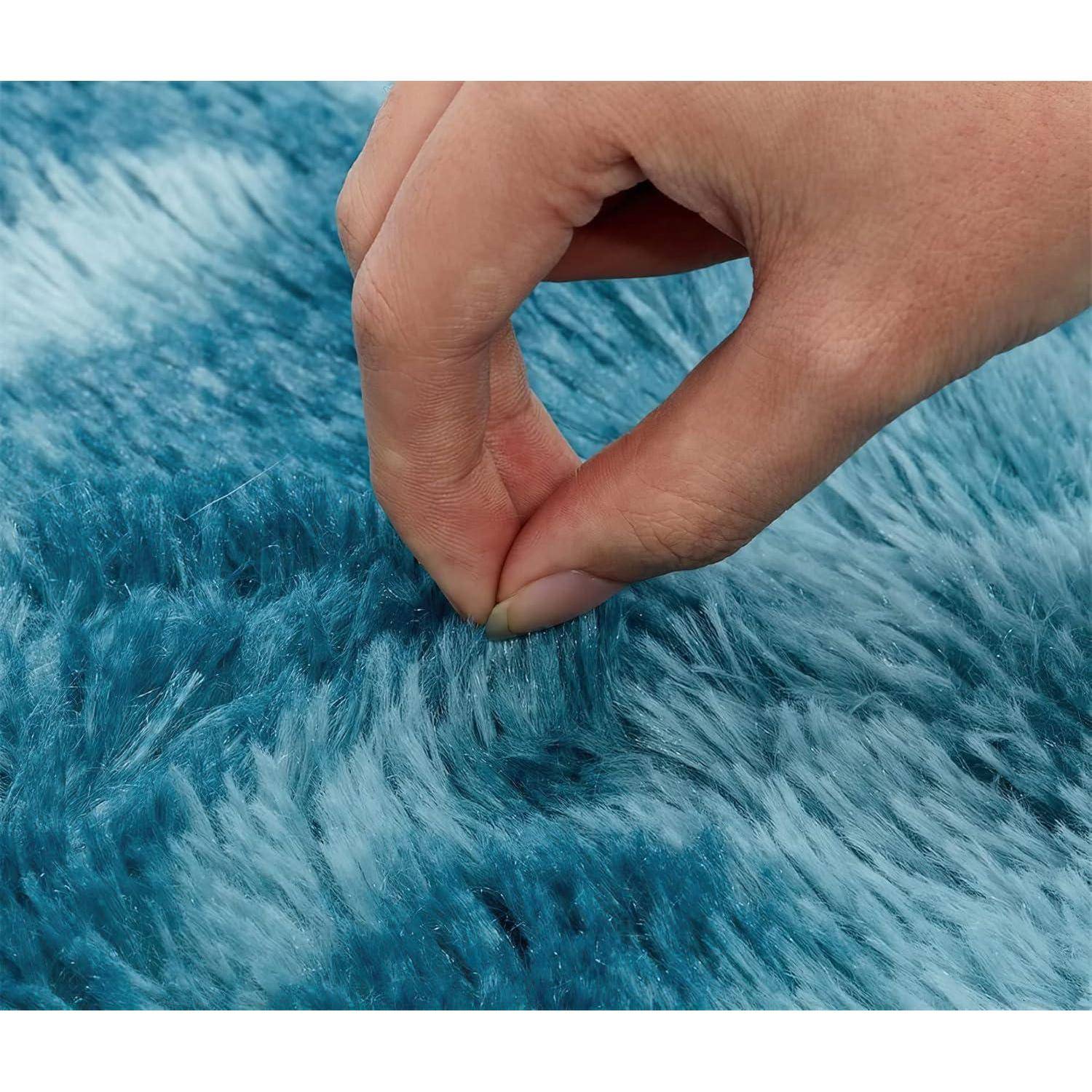 Eine Hand berührt sanft blauen, flauschigen Stoff und zeigt dabei dessen Textur und Weichheit.
