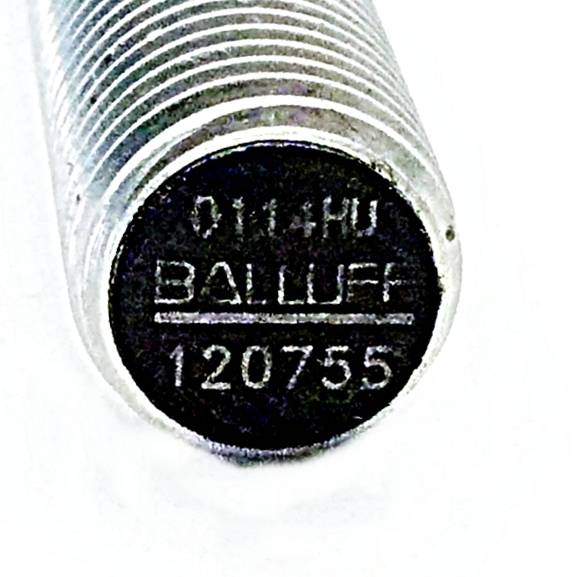 Ein Nahaufnahmebild eines zylindrischen Metallobjekts mit eingraviertem Text '0114HU BALLUFF 120755'.