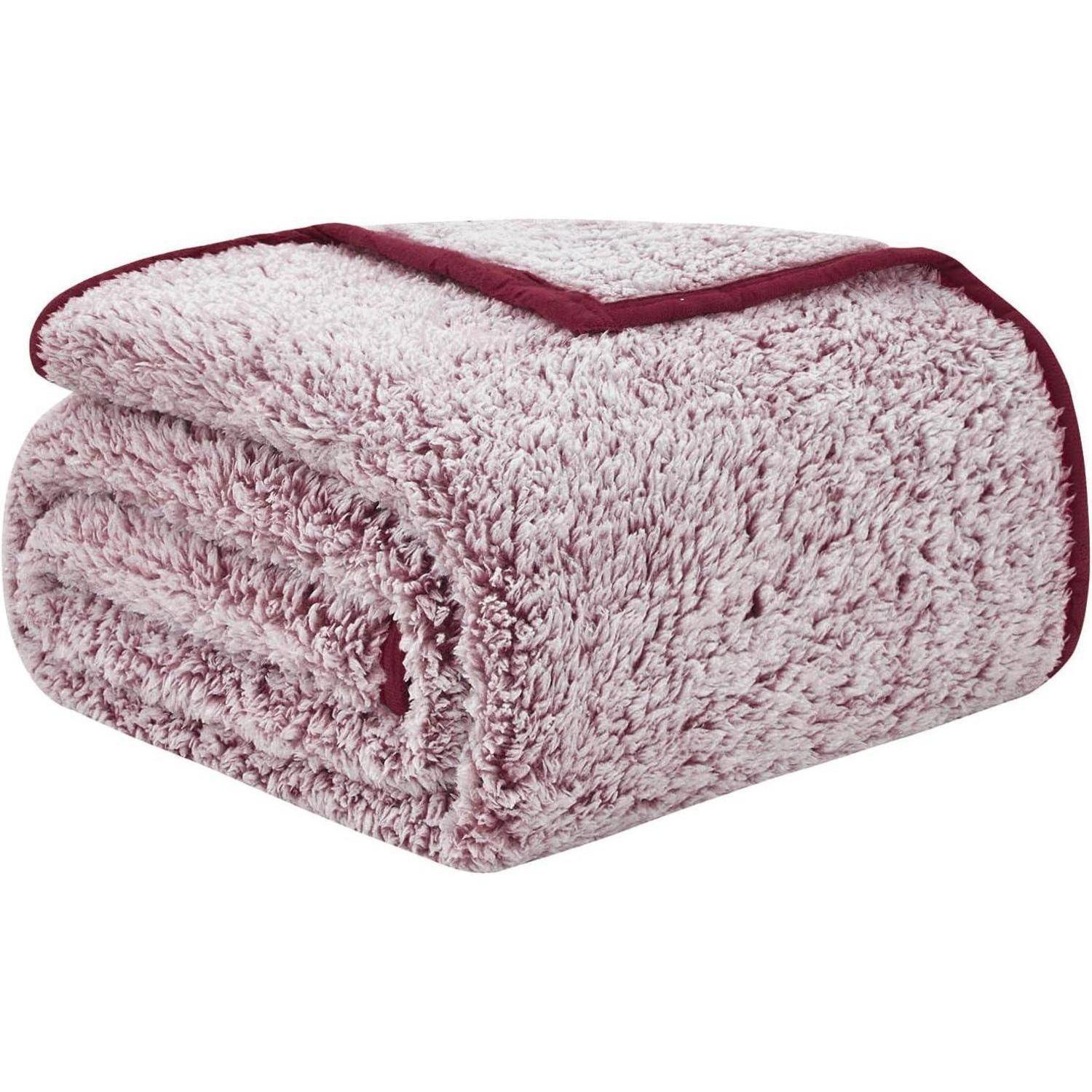 Eine gefaltete, flauschige rosa Decke mit bordeauxrotem Rand.