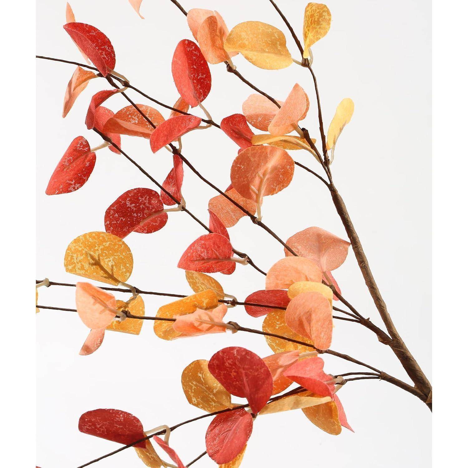 Ein Ast mit leuchtend roten, orangen und gelben Blättern vor einem schlichten weißen Hintergrund, der Herbstlaub repräsentiert.