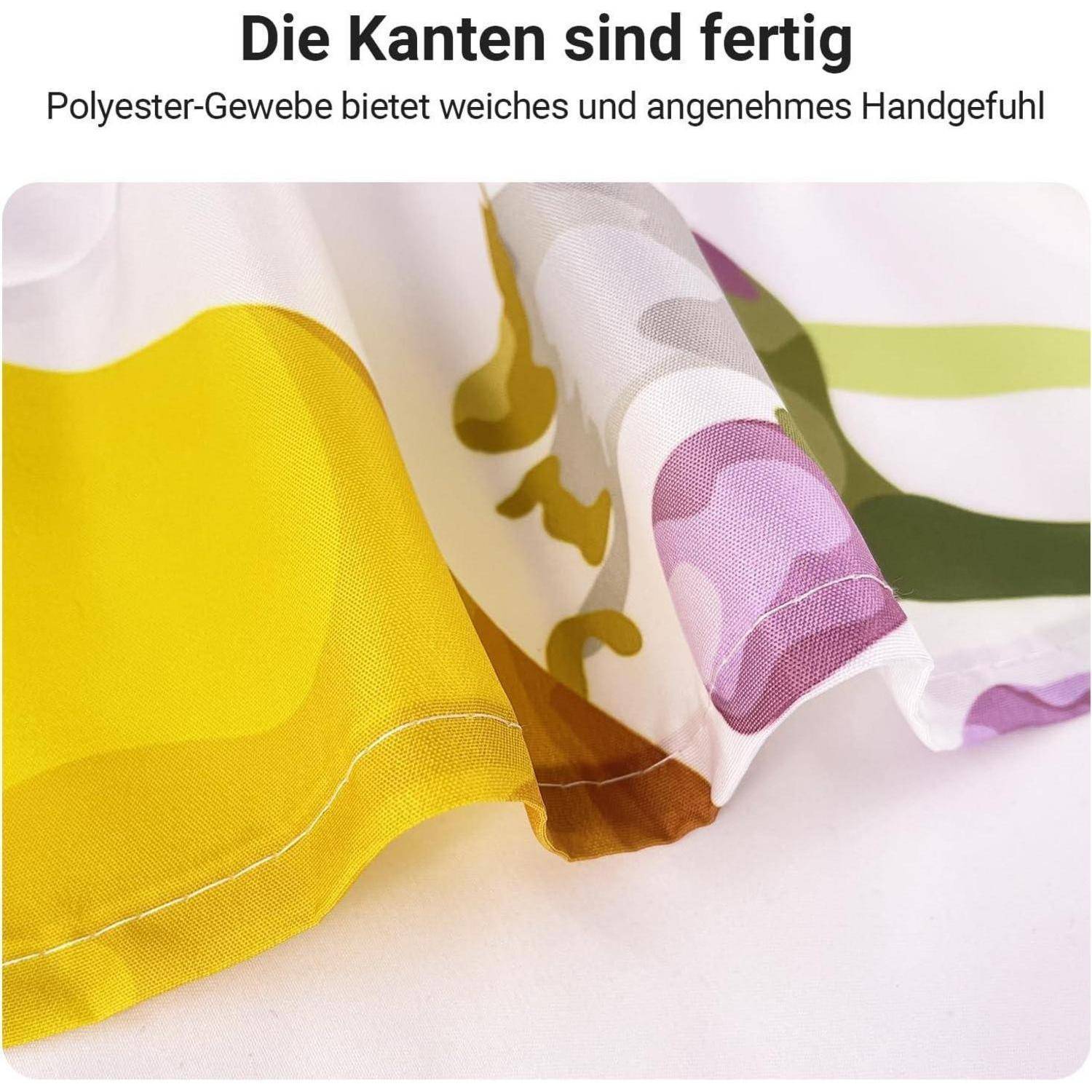 Nahaufnahme von buntem bedrucktem Stoff mit Text auf Deutsch: 'Die Kanten sind fertig. Polyester-Gewebe bietet weiches und angenehmes Handgefühl.