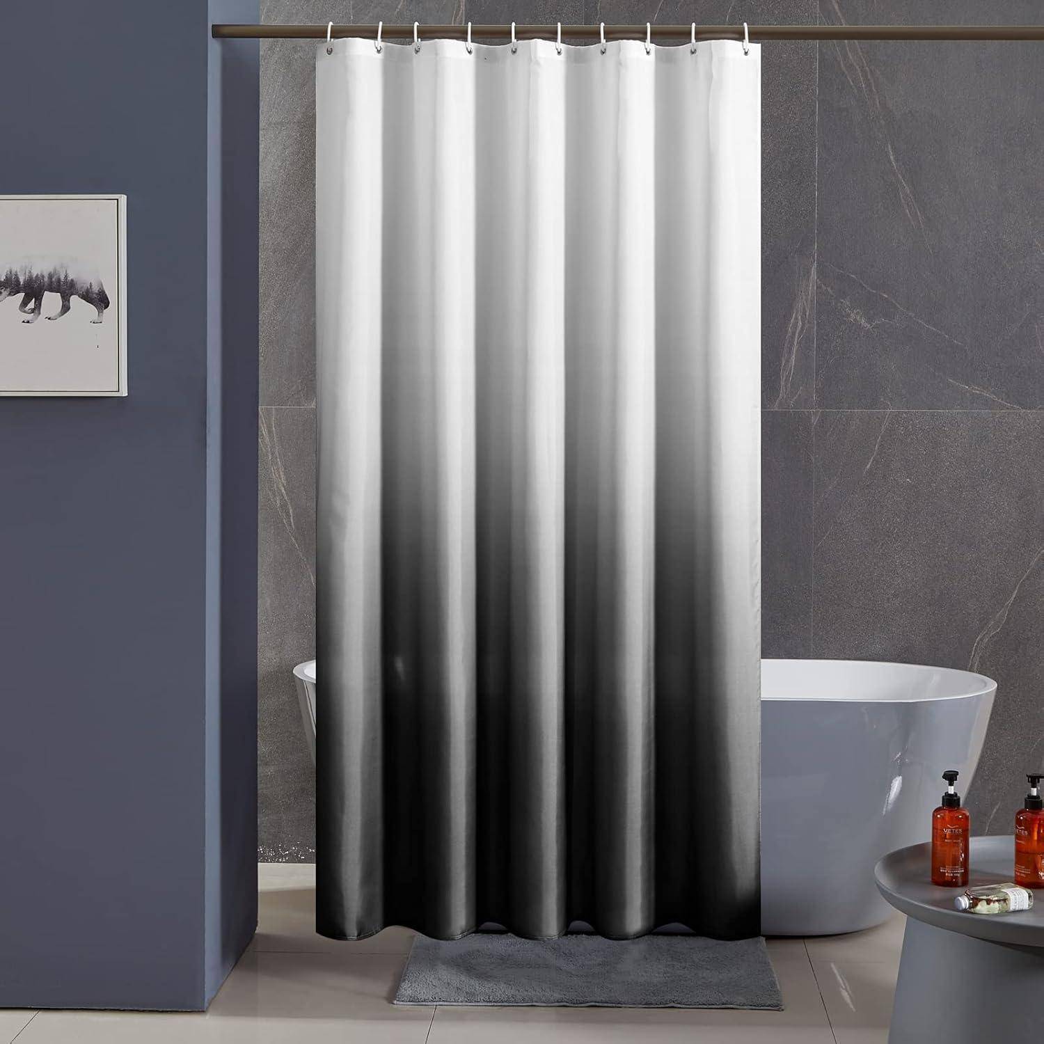 Ein Badezimmer mit einem weißen und grauen Verlauf-Duschvorhang, einer freistehenden weißen Badewanne und Toilettenprodukten auf einem kleinen Tisch daneben.