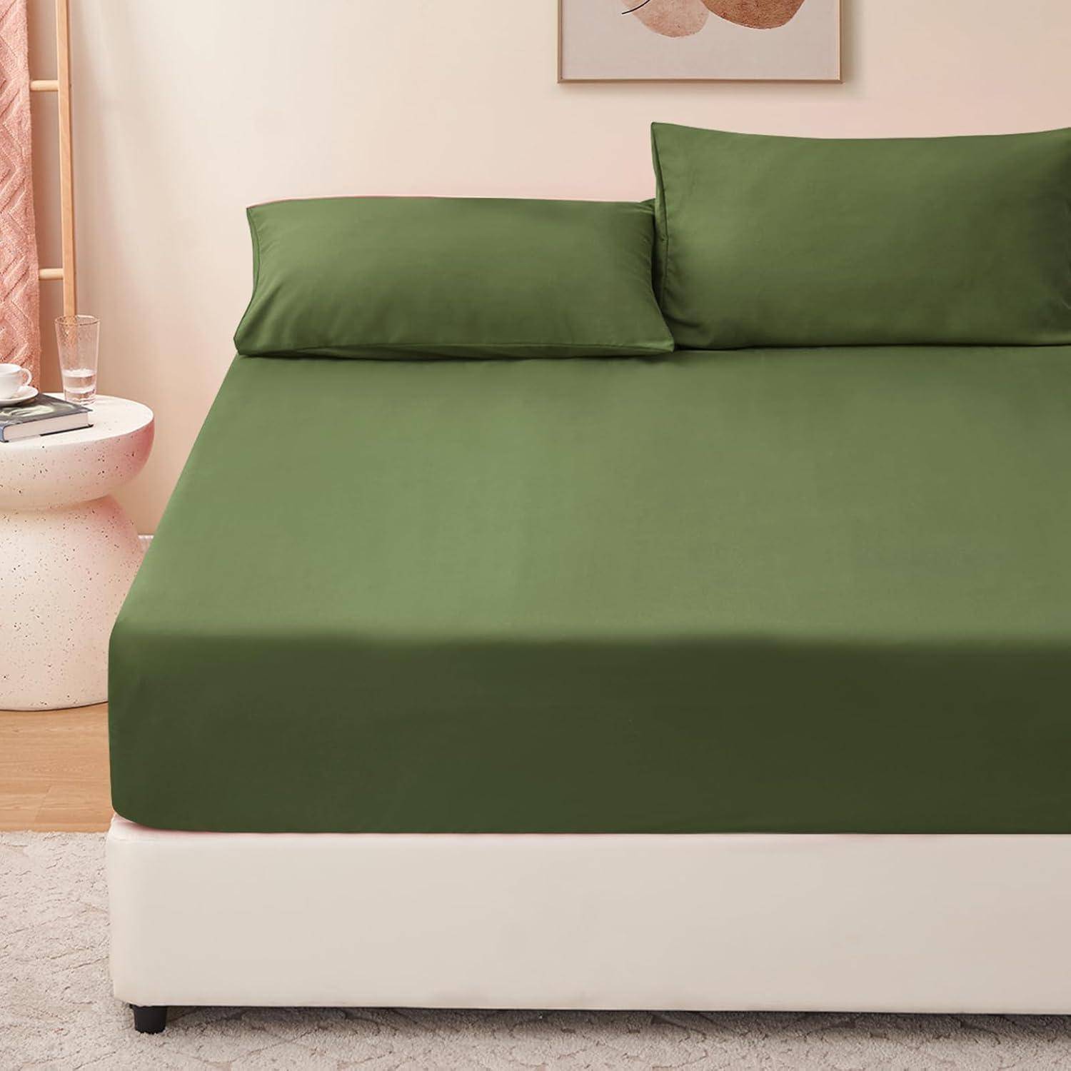 Ein ordentlich gemachtes Bett mit einem grünen Laken und zwei passenden grünen Kissen, platziert in einem modernen Schlafzimmer mit einem runden, weißen Nachttisch.