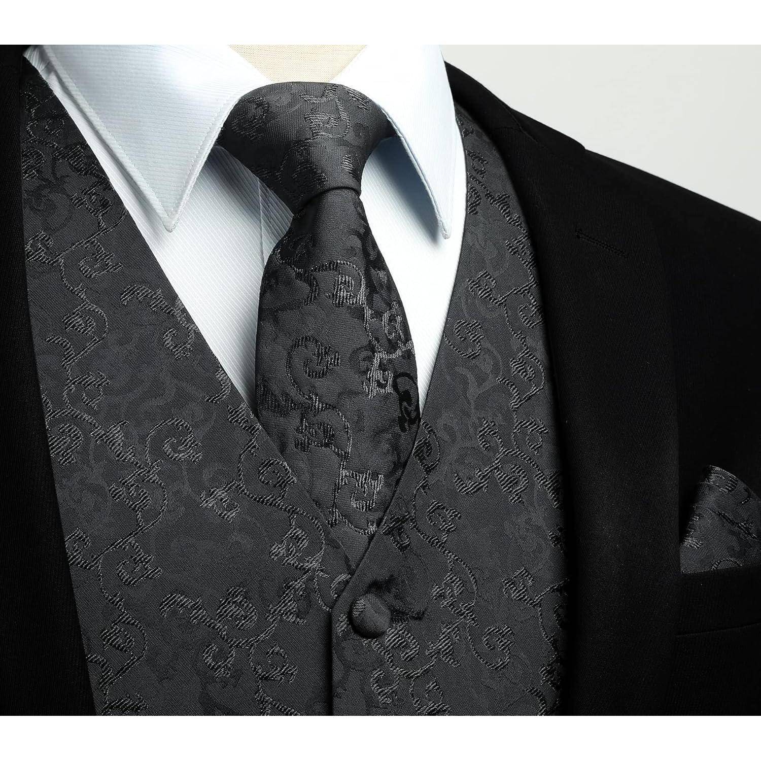 Mann mit einem schwarzen Anzug, einer Krawatte und einer Weste mit Blumenmuster über einem weißen Hemd, der einen eleganten Kleidungsstil präsentiert.