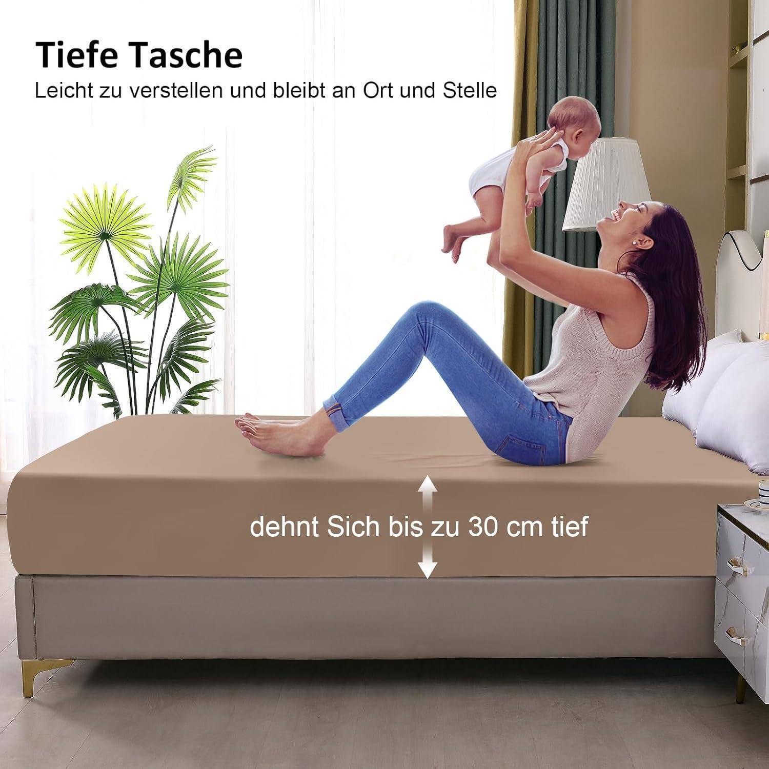 Eine Frau sitzt auf einem Bett, trägt ein weißes Oberteil und blaue Jeans und hält ein Baby in die Luft. Der Text liest sich 'Tiefe Tasche' und 'dehnt Sich bis zu 30 cm tief'.