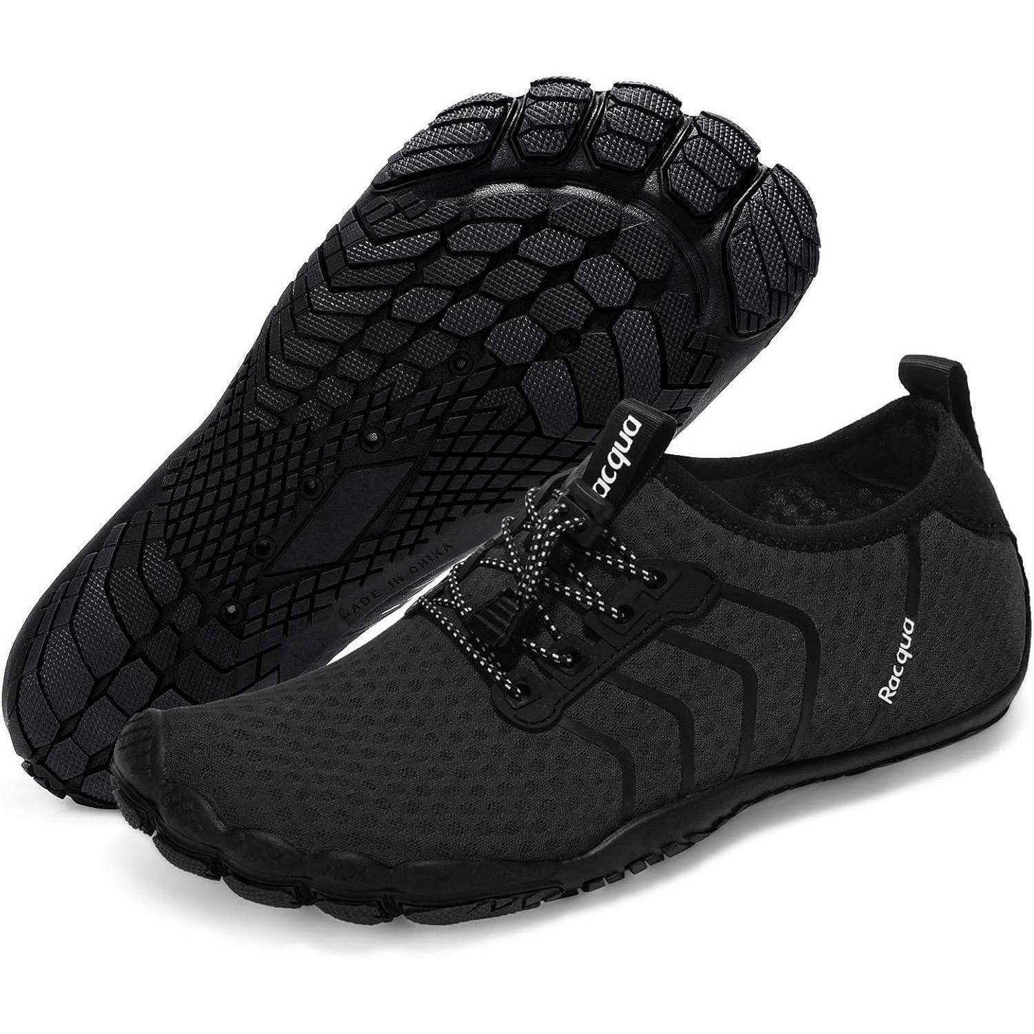 Ein Paar schwarze minimalistische Schuhe mit strukturierten Sohlen, entwickelt für flexible Bewegungen. Ein Schuh steht aufrecht, während der andere mit der Sohle nach oben liegt.