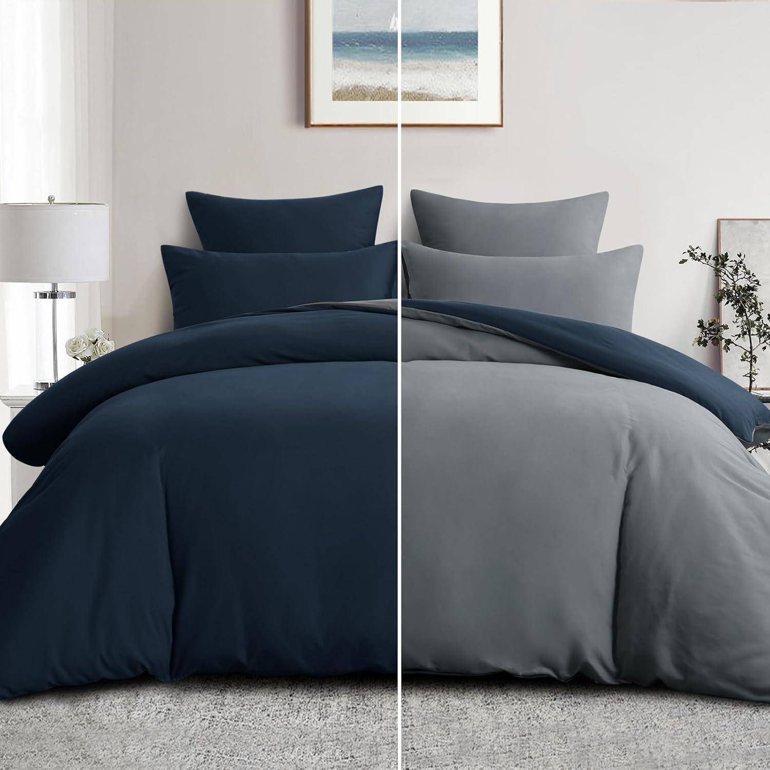 Ein Bett mit geteiltem Design: Eine Hälfte mit marineblauer Bettwäsche und Kissen, die andere Hälfte mit grauer Bettwäsche und Kissen, vor einer neutralen Wand mit gerahmter Kunst.