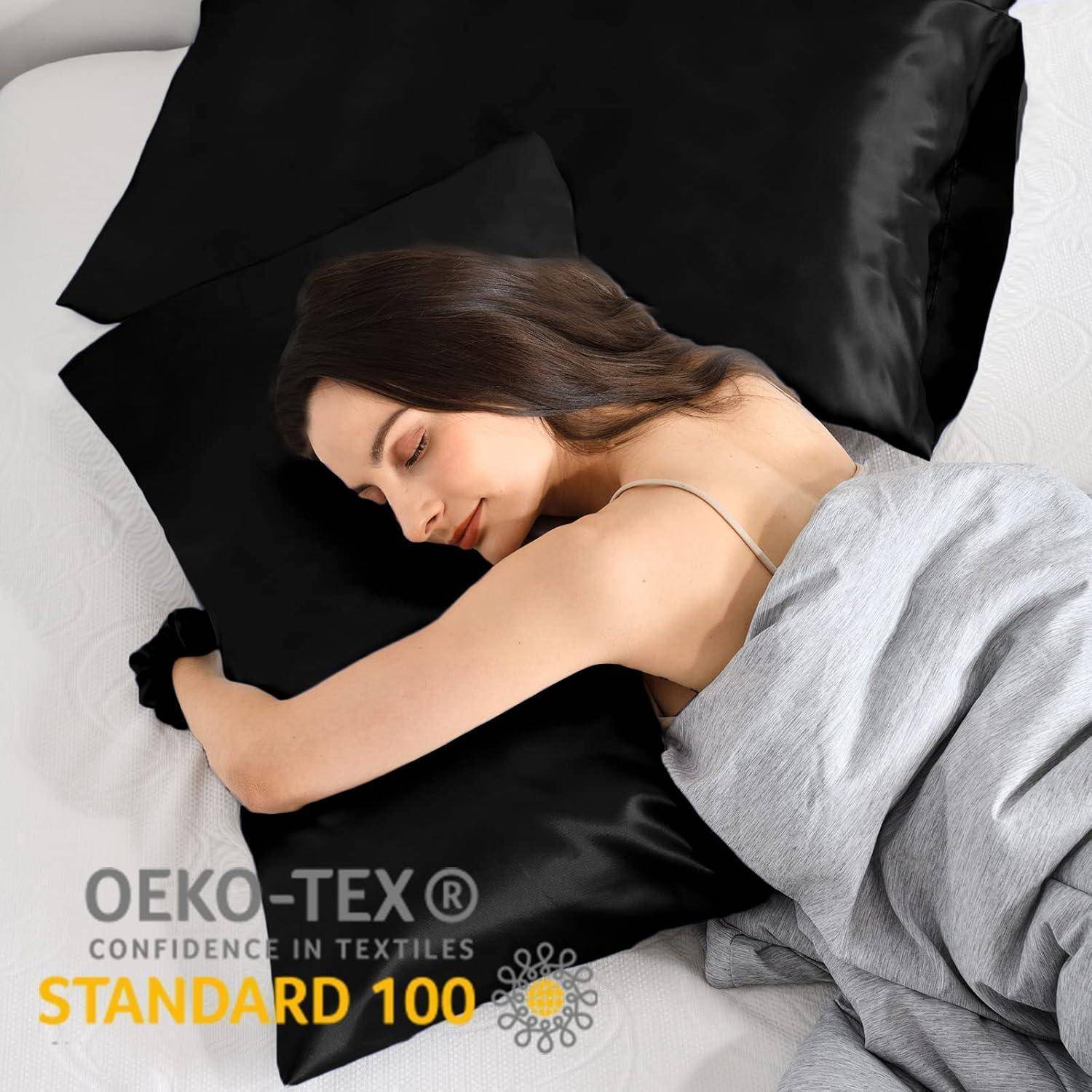 Eine Frau schläft friedlich auf einem Bett mit schwarzen Seidenkissenbezügen. Das Etikett ‚STANDARD 100 by OEKO-TEX' weist auf geprüfte Textilsicherheit hin.