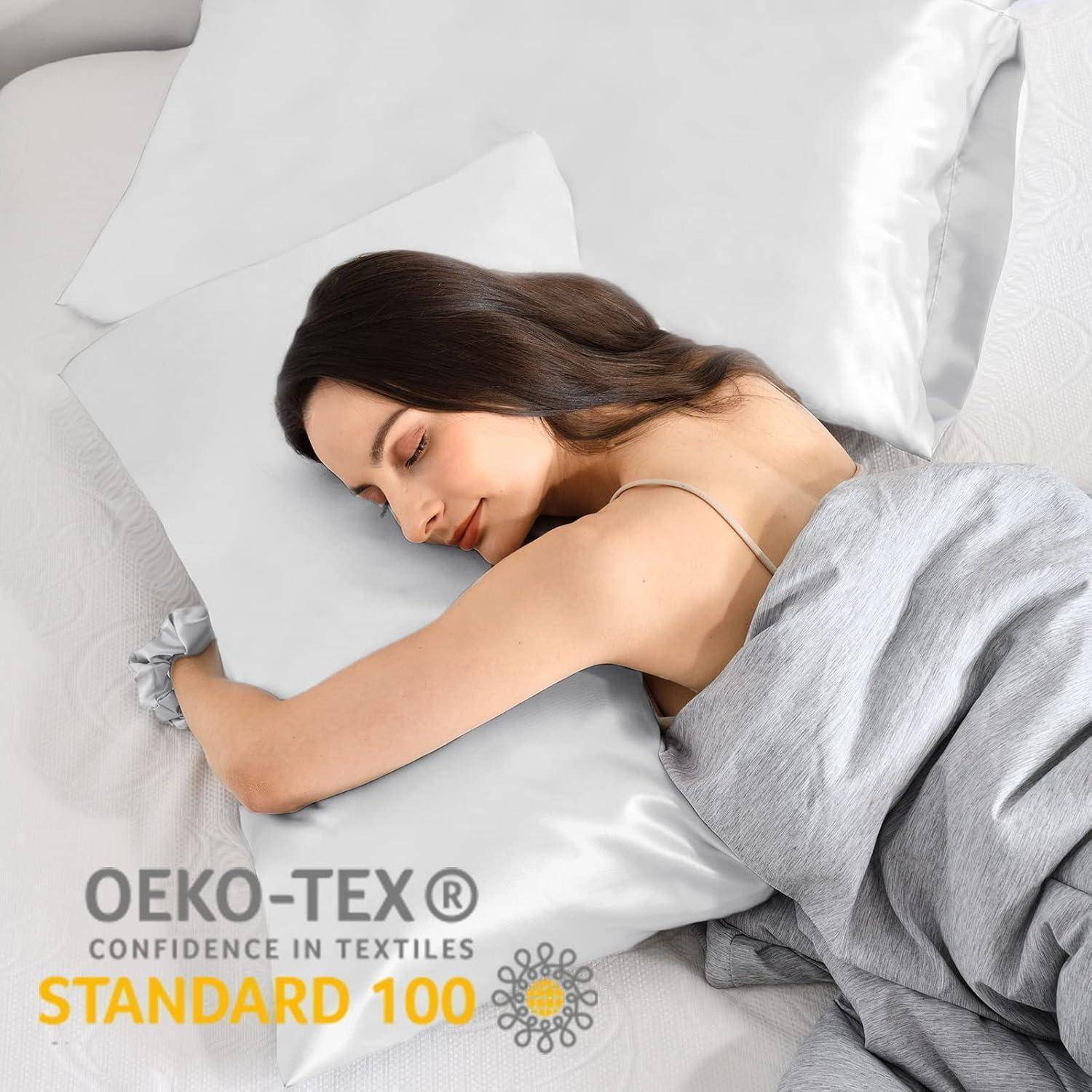 Eine Person schläft auf einem Bett mit weißen Betttüchern, bedeckt von einer grauen Decke. Das Bild zeigt ein Etikett mit der Aufschrift „OEKO-TEX Confidence in Textiles STANDARD 100
