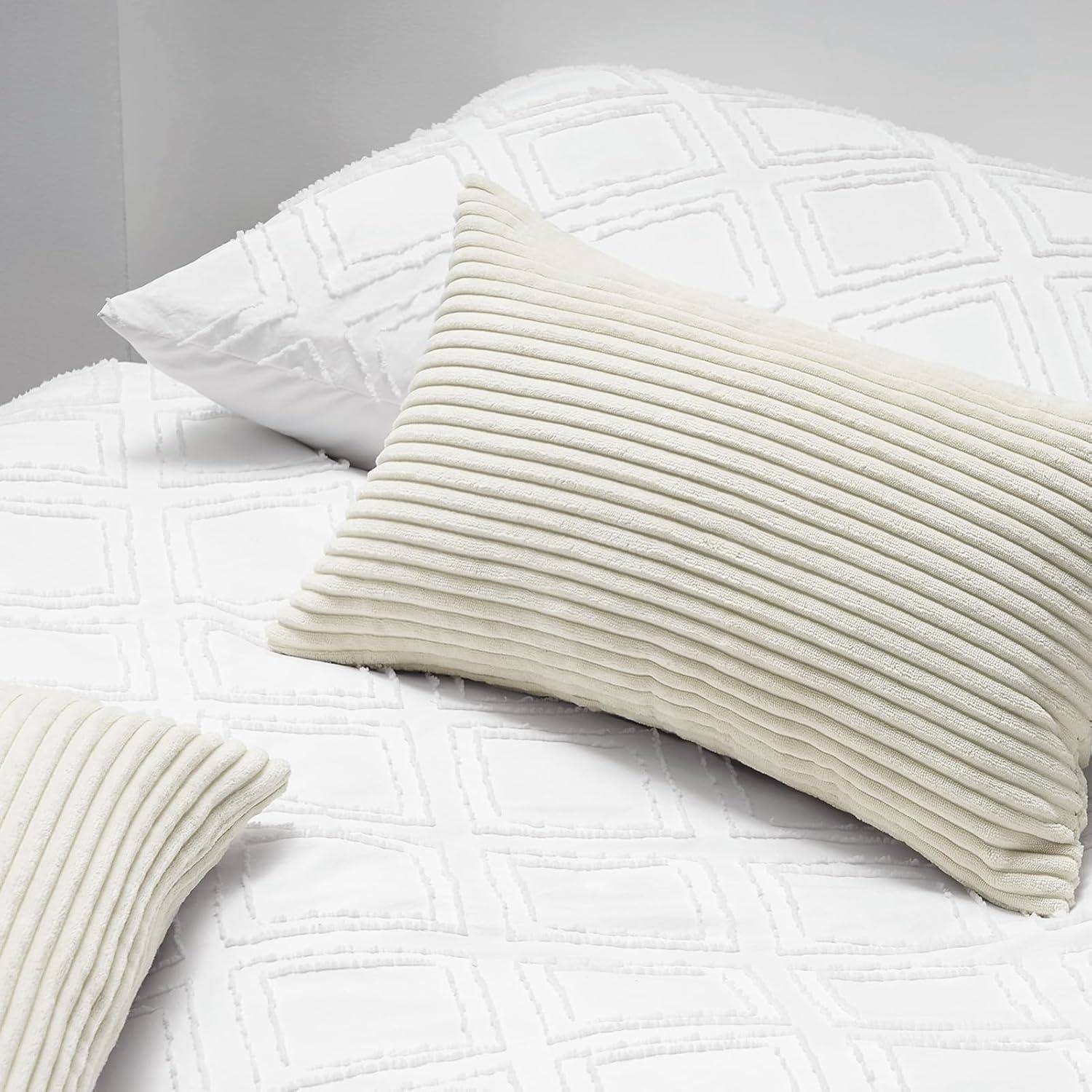 Ein ordentlich gemachtes Bett mit einem strukturierten cremefarbenen Kissen und einer passenden Decke. Die Bettwäsche weist ein dezentes geometrisches Muster auf.