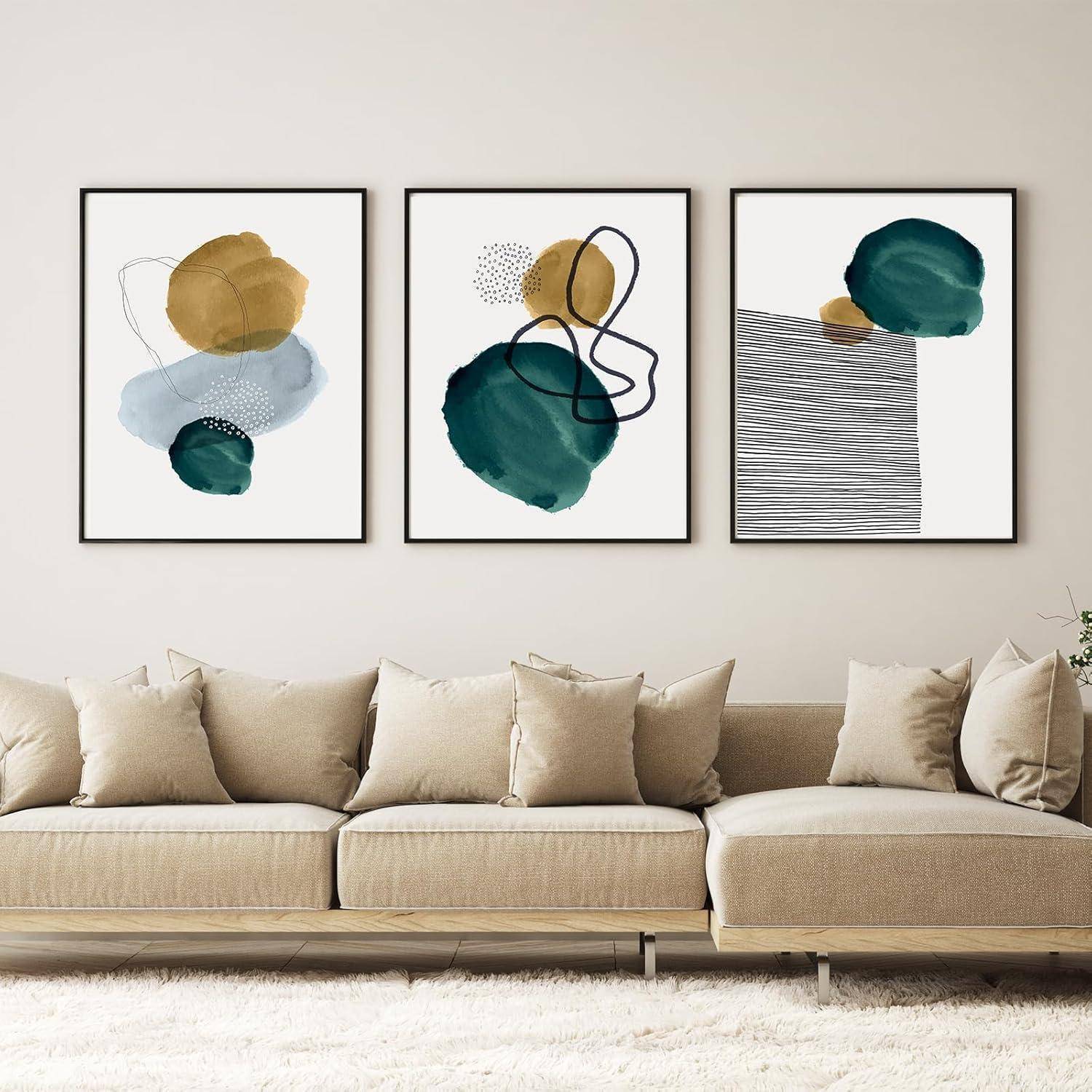 Drei abstrakte Kunstdrucke mit Kreisen und Linien in erdigen Tönen hängen über einem beigen Sofa in einem modernen Wohnzimmer.