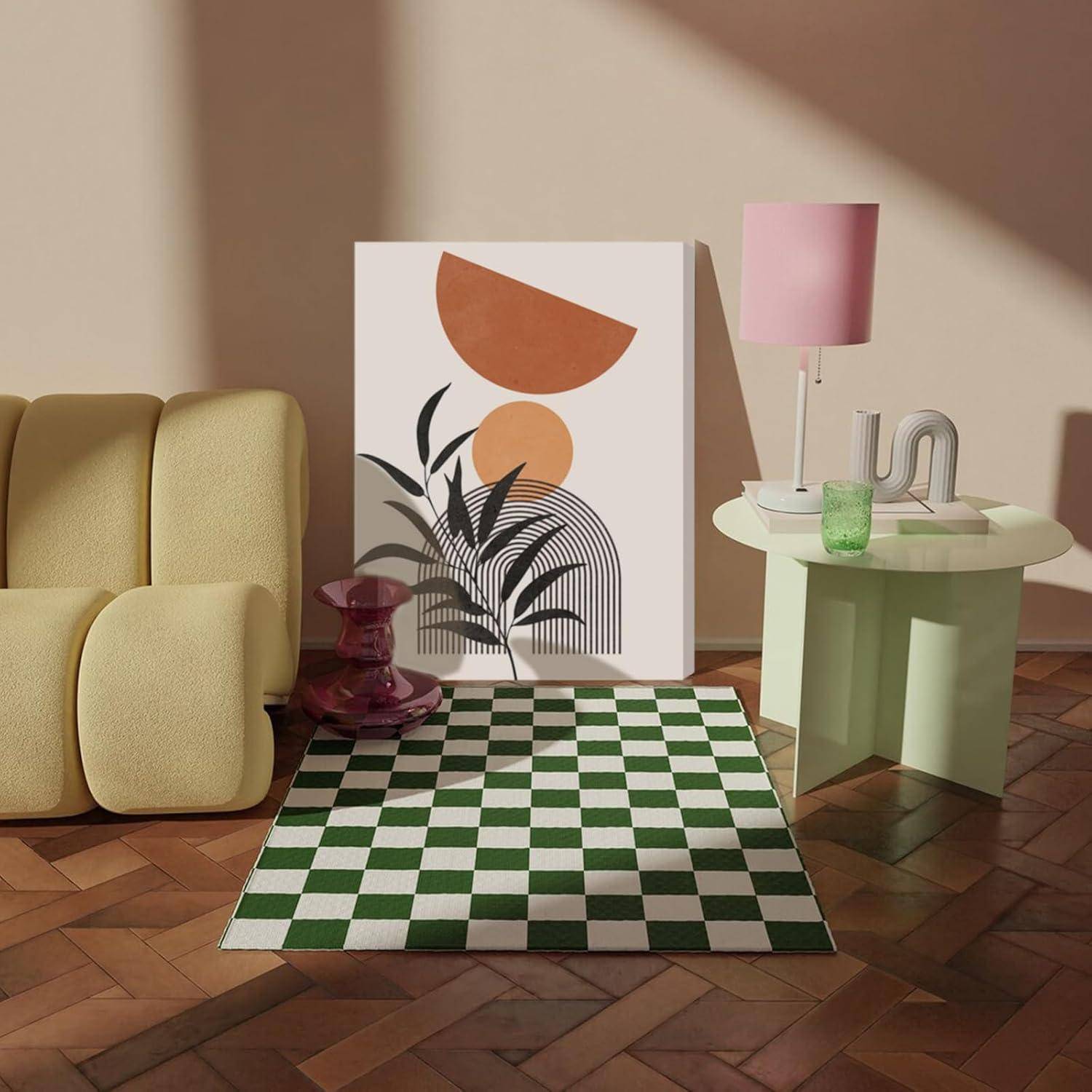 Ein Raum mit einem gelben Sofa, einem grün karierten Teppich, abstrakter Wandkunst, einem mintfarbenen Beistelltisch, einer rosa Lampe und einer rosa Vase auf einem Holzboden.