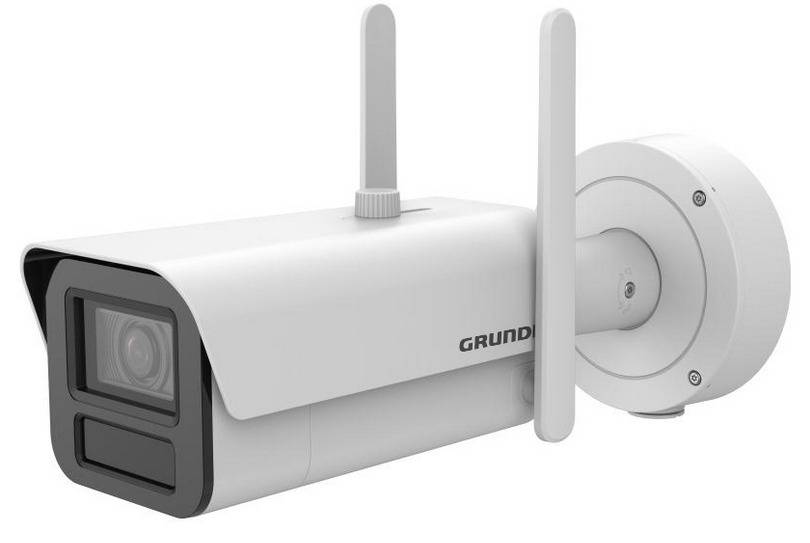 Eine weiße Sicherheitskamera mit Doppelantenne und Objektivdeckel, auf einem Schwenkhalterung montiert, mit dem 'Grundig' Logo versehen.