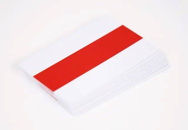 Ein leerer Stapel weißer Karten oder Papier mit einem roten oberen Blatt, isoliert auf weißem Hintergrund.