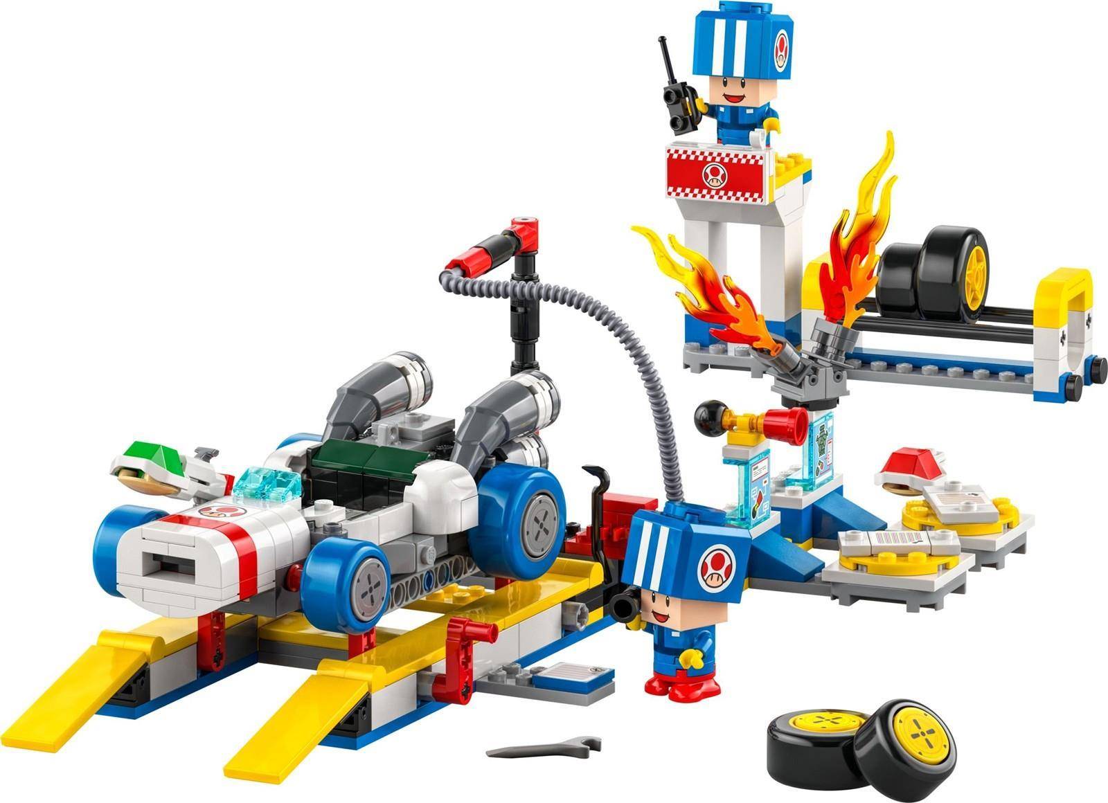 LEGO-Rettungsszene mit einem Feuerwehrauto, Flammen, einem Hubschrauber, einem kleinen Boot, zwei Minifiguren und losen Rädern auf weißem Hintergrund.