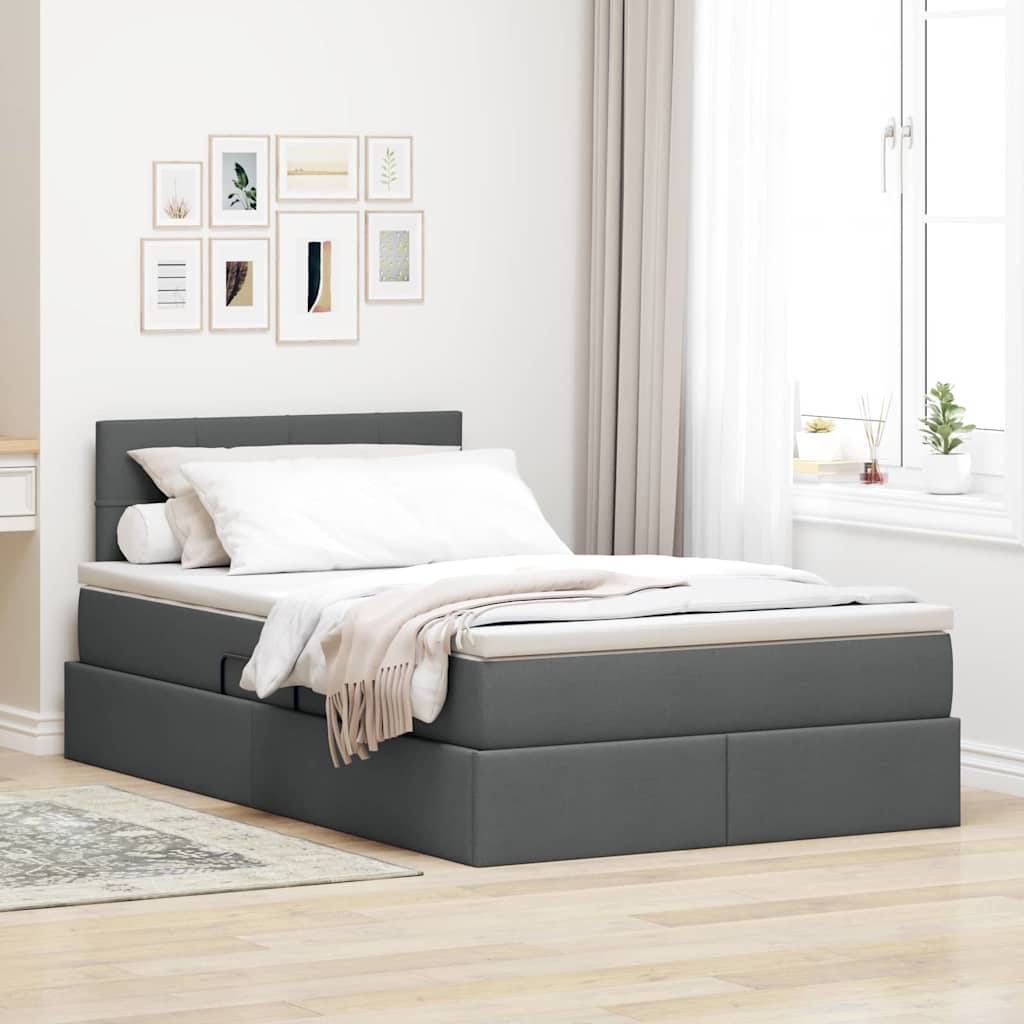 Ein ordentlich gemachtes Bett mit grauer gepolsterter Basis in einem hellen Zimmer. Die Wand zeigt eine kleine Galerie mit gerahmten Kunstwerken, und ein weißer Vorhang hängt am Fenster.