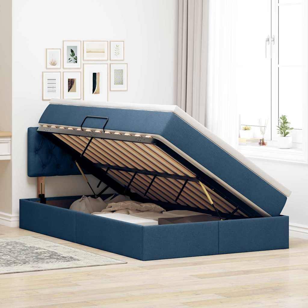 Ein blaues gepolstertes Bett mit einem offenen hydraulischen Stauraum, in dem Kissen und Bettwäsche zu sehen sind, in einem hellen, modernen Schlafzimmer.