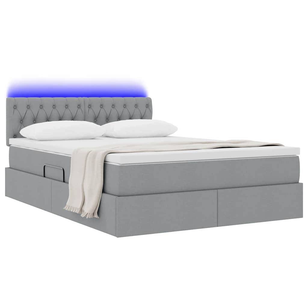 Ein modernes Bett mit grauem gepolstertem Gestell, blau beleuchtetem getuftetetem Kopfteil, weißer Matratze und beigefarbener Decke, von der Seite betrachtet.