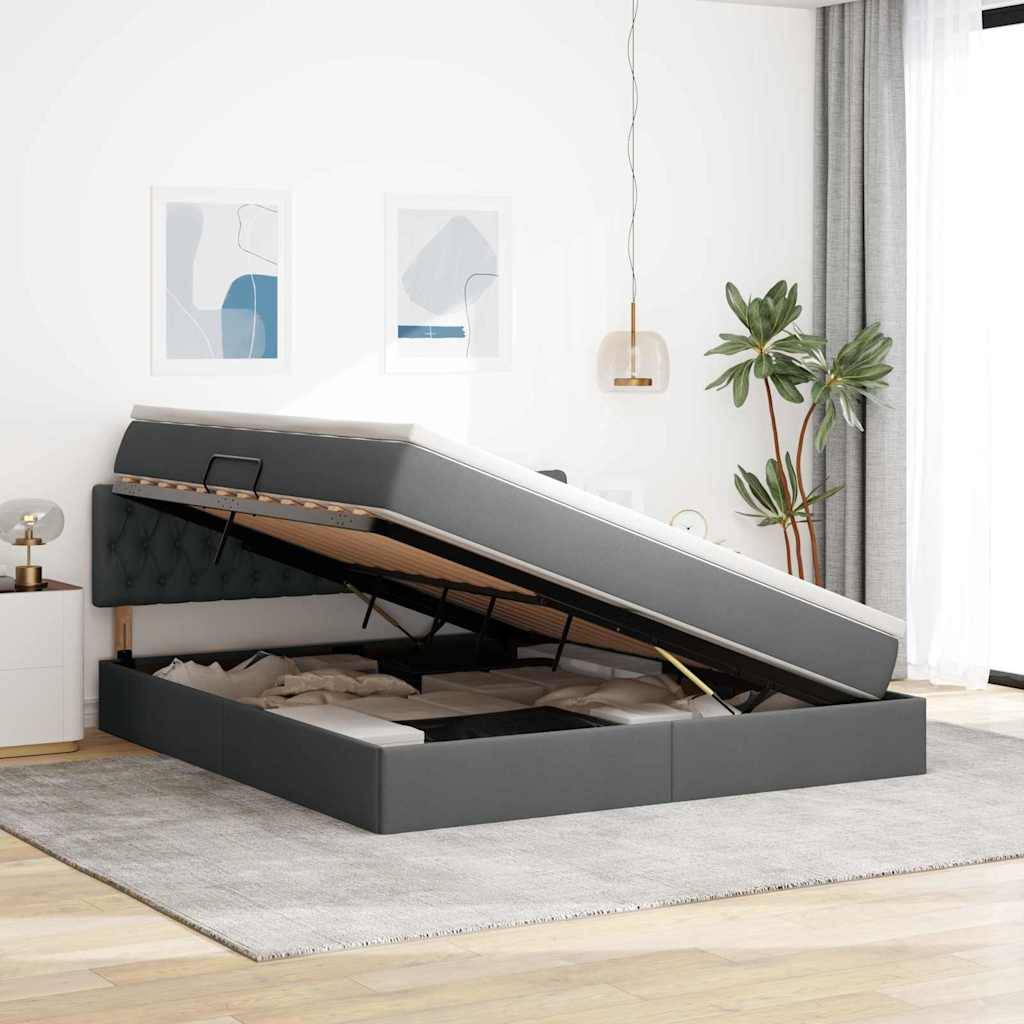 Ein Schlafzimmer mit einem grau gepolsterten Speicherbett, Matratze angehoben, um den Stauraum darunter freizulegen, Holzboden und moderner Einrichtung.