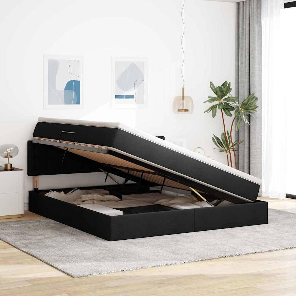 Ein stilvolles Schlafzimmer mit einem schwarzen Speicherbettrahmen, angehoben, um den Stauraum unter dem Bett freizulegen. Die moderne Einrichtung umfasst abstrakte Kunst und Pflanzen.