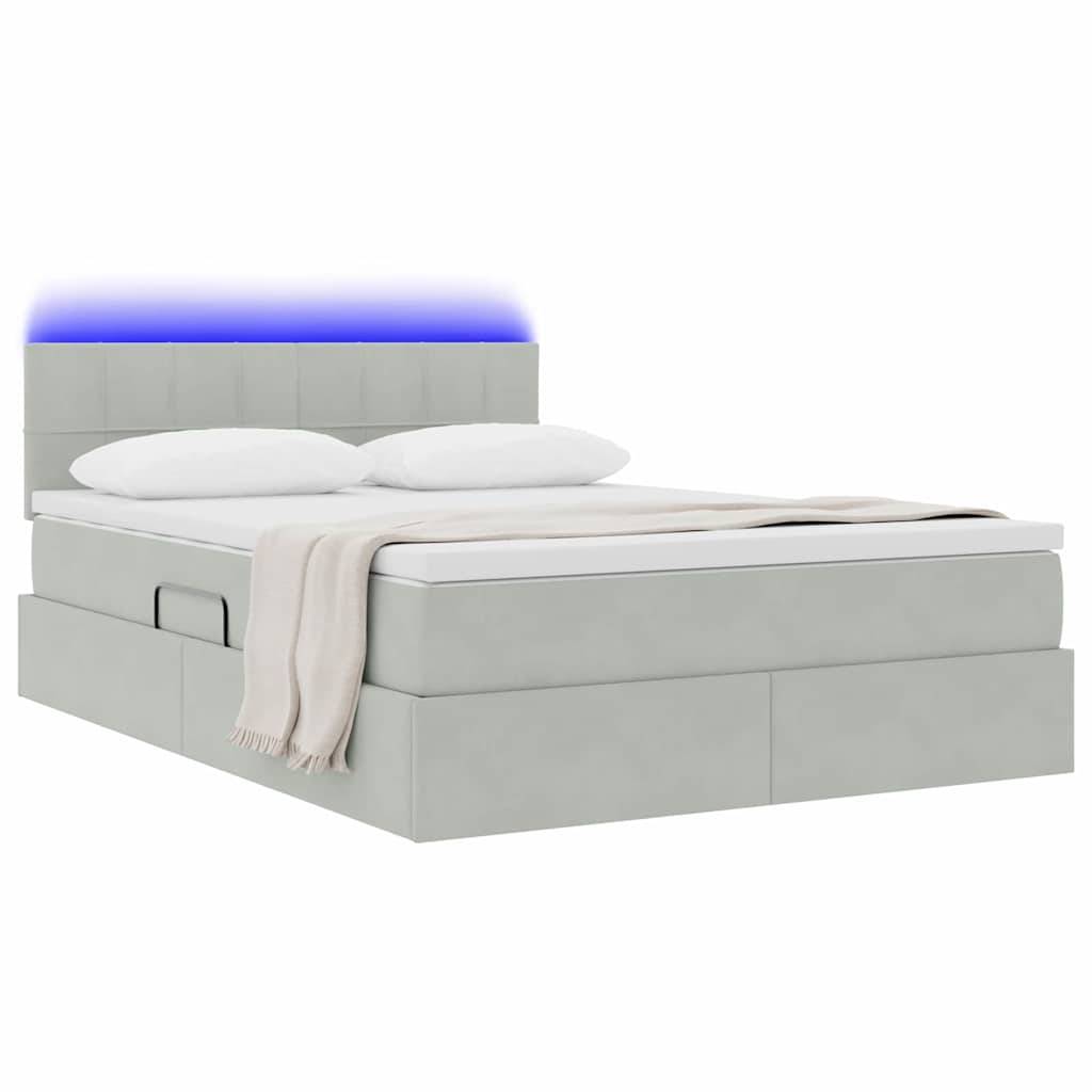 Ein modernes graues Bett mit gestepptem Kopfteil und stimmungsvoller blauer Beleuchtung. Es verfügt über eine weiche beige Decke und zwei weiße Kissen obenauf.