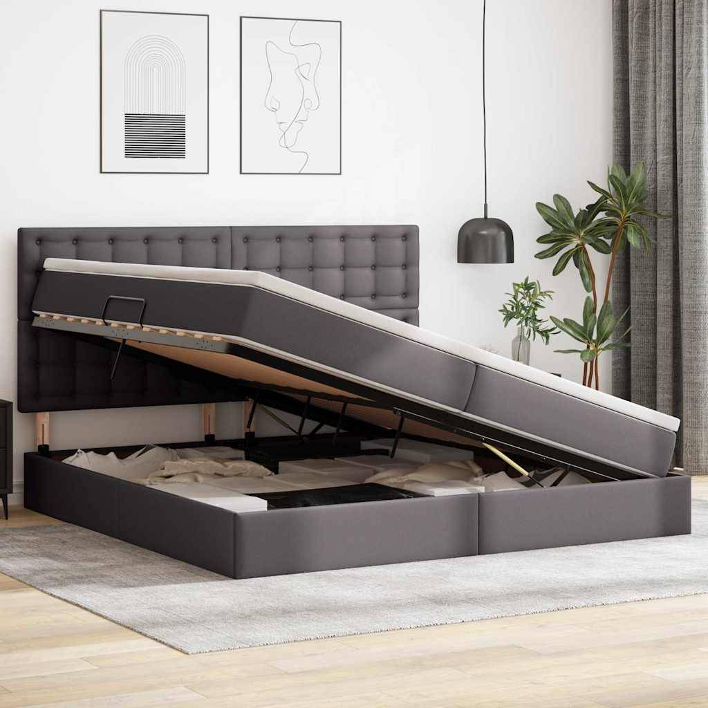 Ein modernes Bett mit einem grau gepolsterten Kopfteil ist zu sehen, wobei die Matratze angehoben ist, um den Stauraum darunter freizulegen. Der Raum ist minimal eingerichtet.