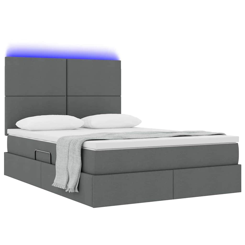Ein modernes graues Bett mit einer beleuchteten Kopfleiste, einer ordentlich arrangierten hellgrauen Decke und zwei weißen Kissen.