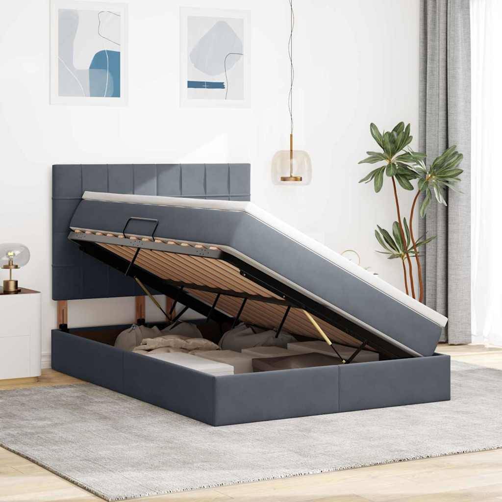 Ein modernes Schlafzimmer mit einem erhöhten, grau gepolsterten Bett mit Stauraum, das den Stauraum darunter zeigt. Minimalistische Dekoration mit gerahmter Kunst und einer Topfpflanze.