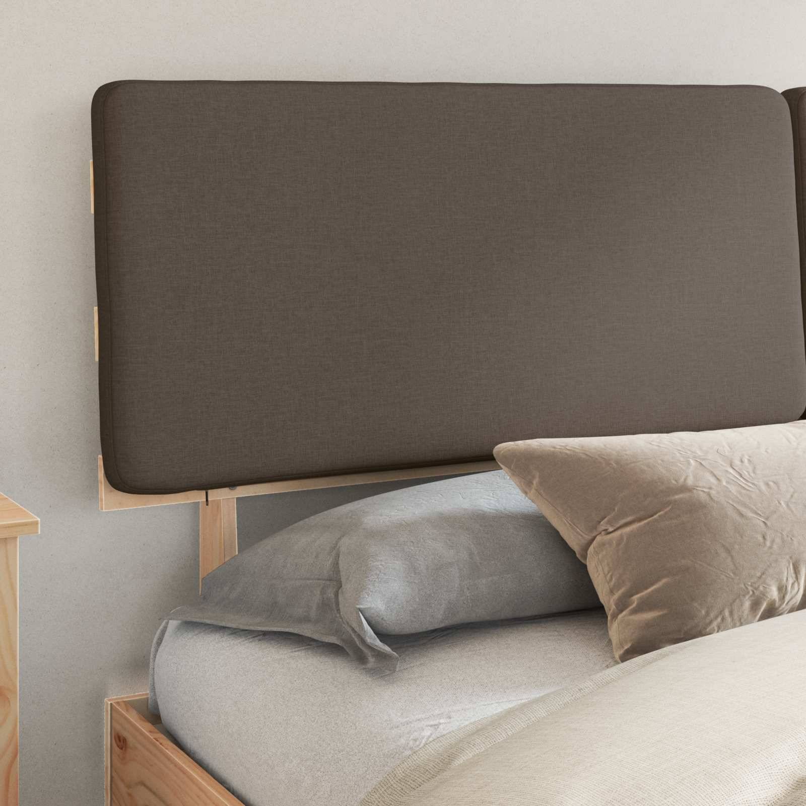 Ein Holzbett mit grauer Bettwäsche verfügt über einen großen, braunen rechteckigen gepolsterten Kopfteil und ein beige Kissen, das in einer Schlafzimmerecke platziert ist.