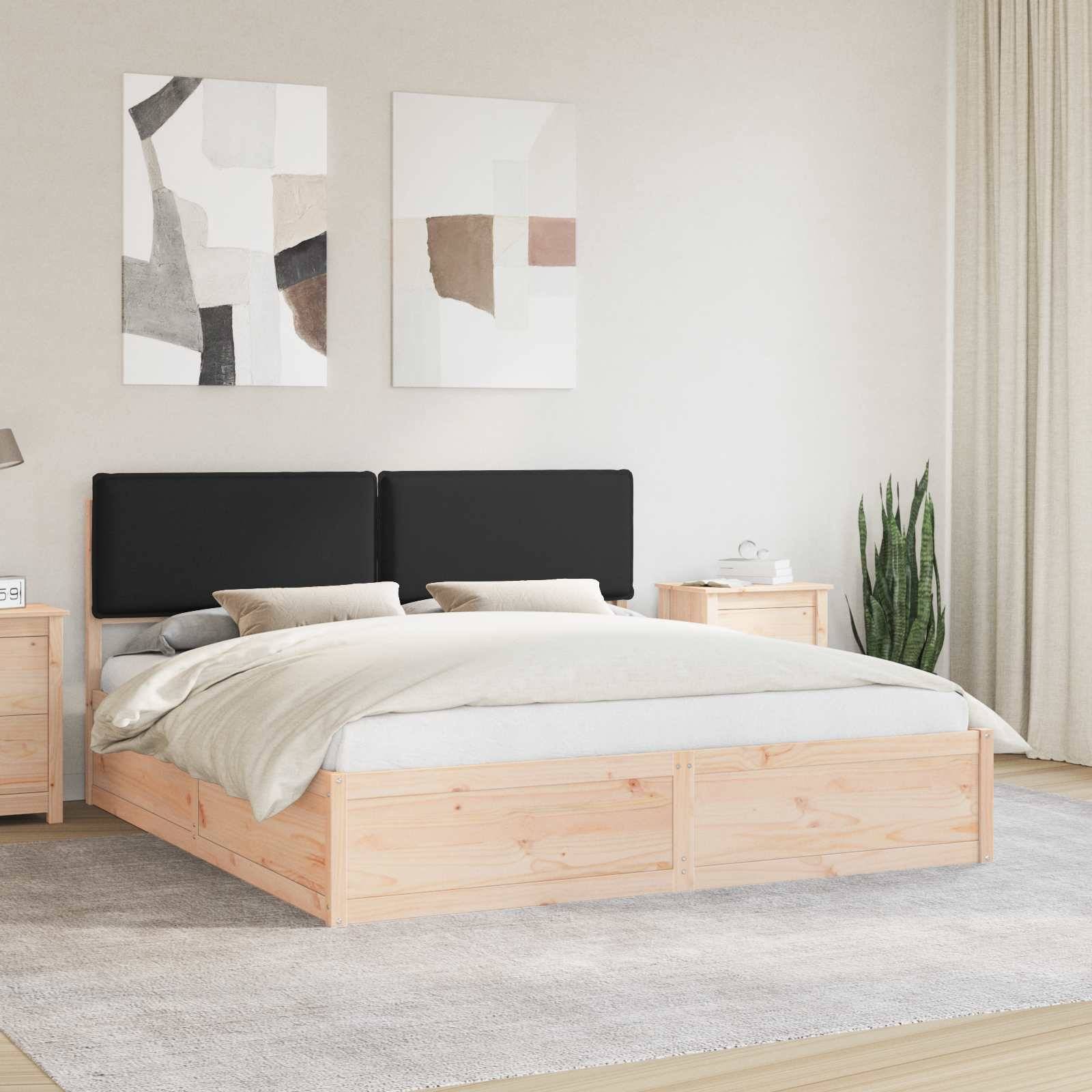 Ein modernes Schlafzimmer mit einem Bettgestell aus hellem Holz, schwarzem Kopfteil, hellgrauer Bettwäsche und zwei abstrakten Gemälden an der Wand.
