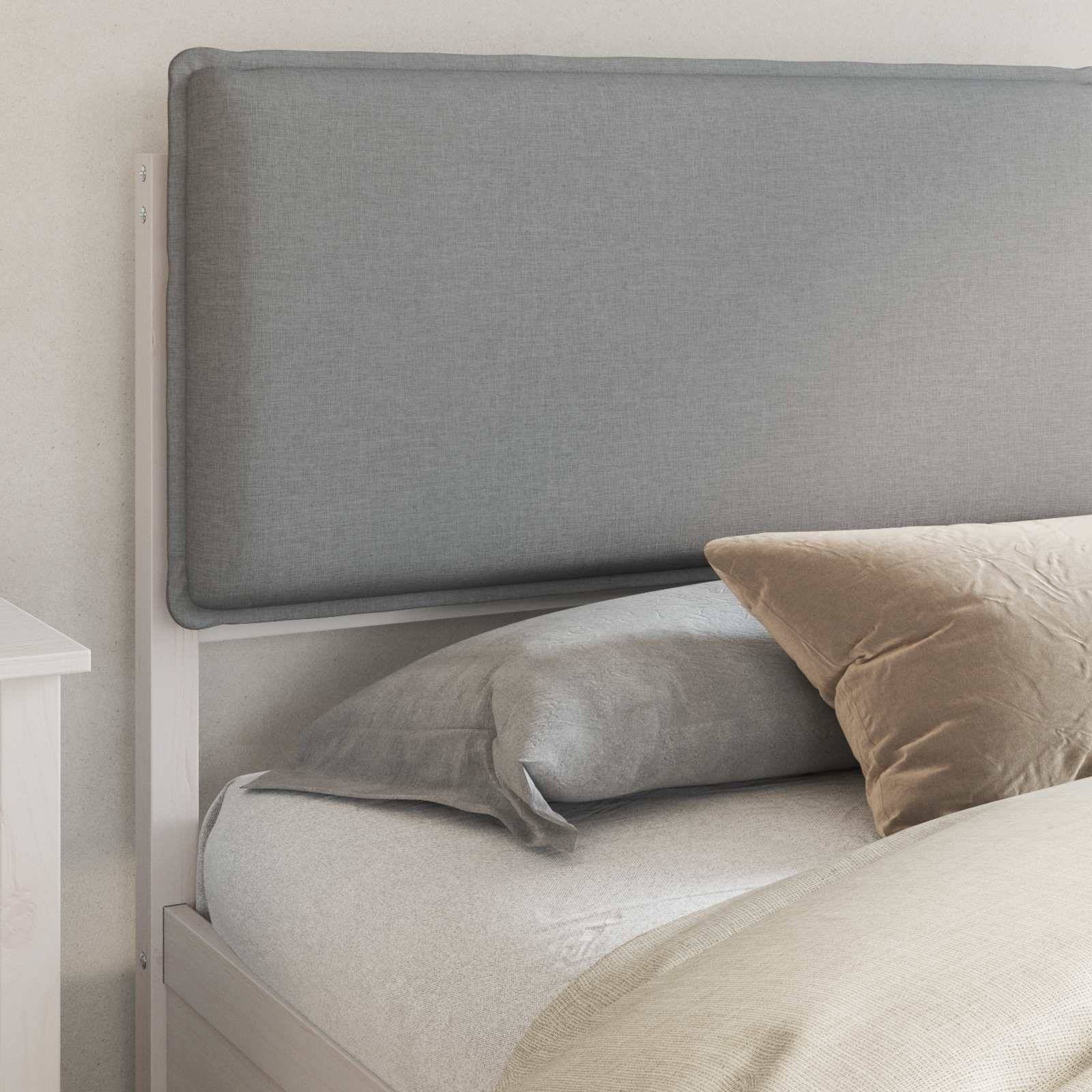 Ein ordentlich gemachtes Bett mit grauer Bettwäsche und einem beigen Kissen ist an einer hellen Wand neben einem weißen Nachttisch platziert.